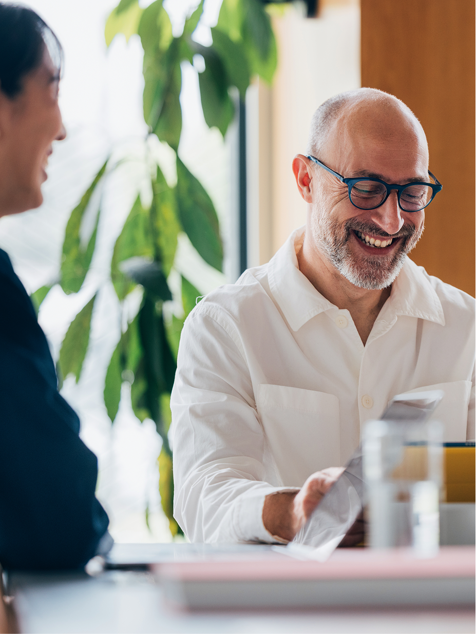 A founder smiling during a consultation over documents