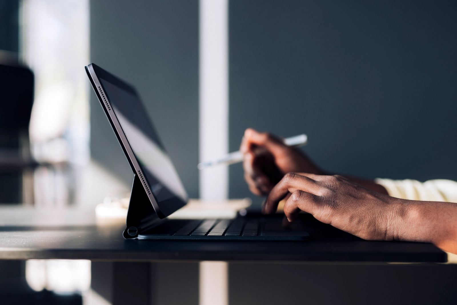 Hands uploading case documents using a tablet and keyboard
