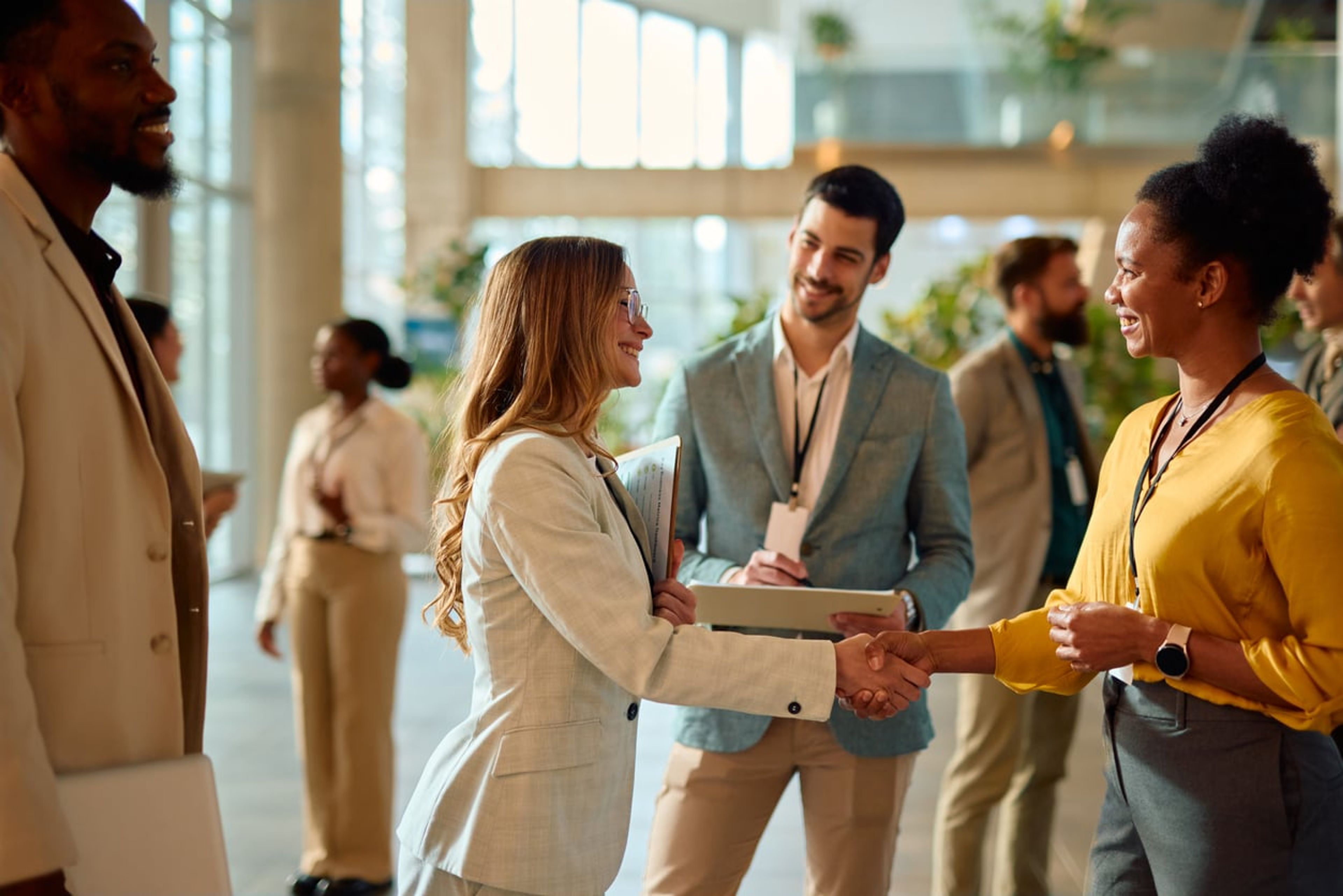 Two businesswomen shaking hands during a conference meeting.