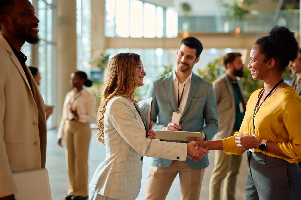 Two businesswomen shaking hands during a conference meeting.