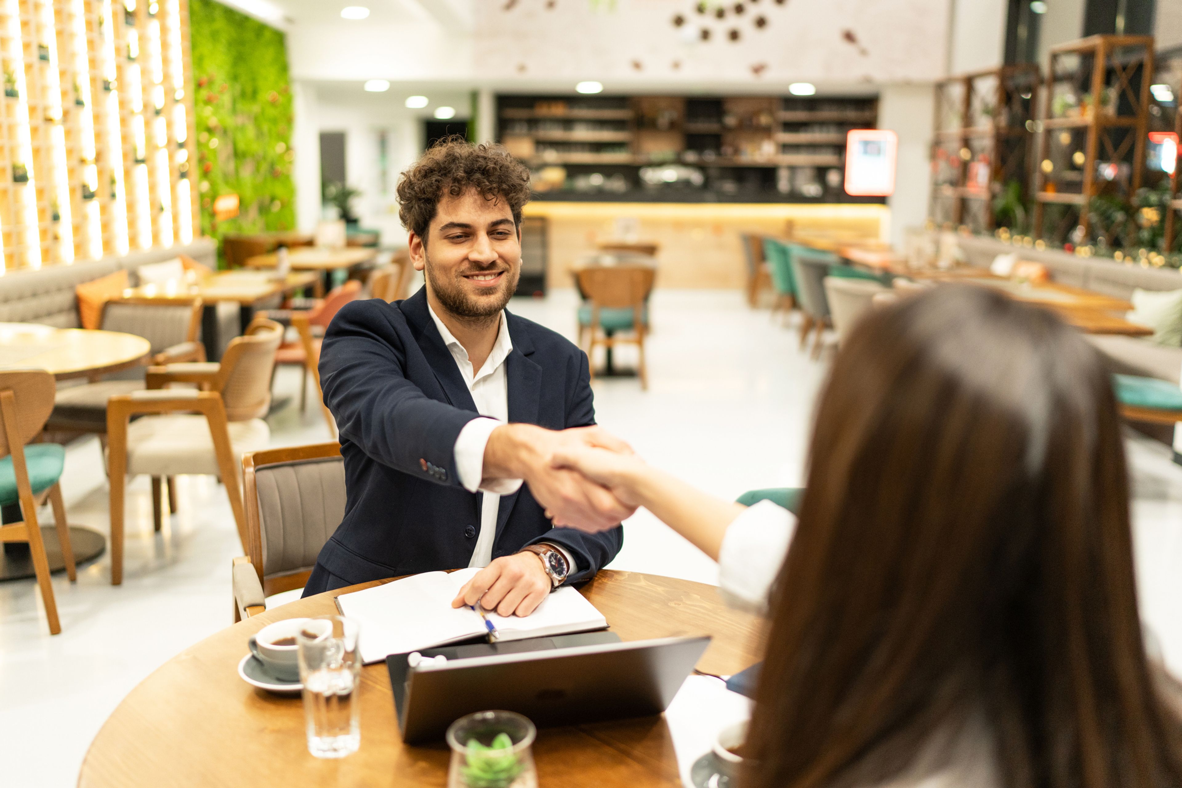 Two business professionals shaking hands in a restaurant