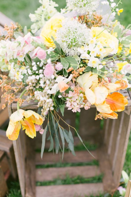 ceremony arrangement of tulips, white allium, stock, pieris, globe amaranthus and yellow roses