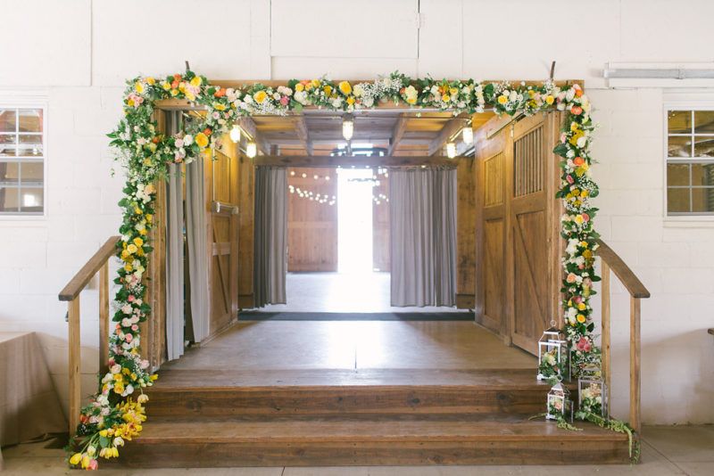 asymetrical garland of white, pink, yellow and peach flowers accented with silver arrangment lanterns