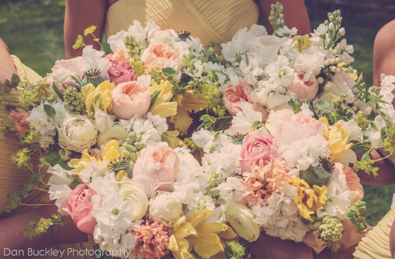 bridesmaids bouquets of white, peach, pink and yellow flowers
