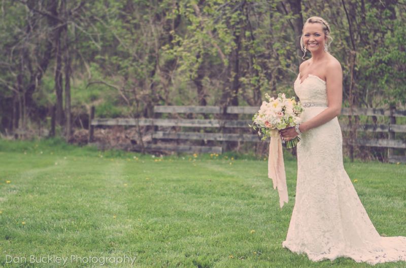 a white rounded with texture bouquet with hint of pink and yellow flowers, with raw silk ribbon in various natural soft shades
