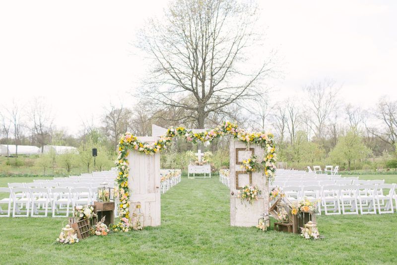 lush garland of yellow, pink, peach and white flowers accented with vintage decor and spilling flower lanterns