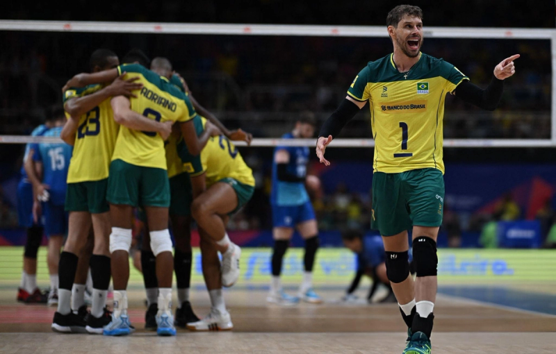 Brazilian volleyball players in yellow uniforms celebrate on court, with one player pointing energetically.