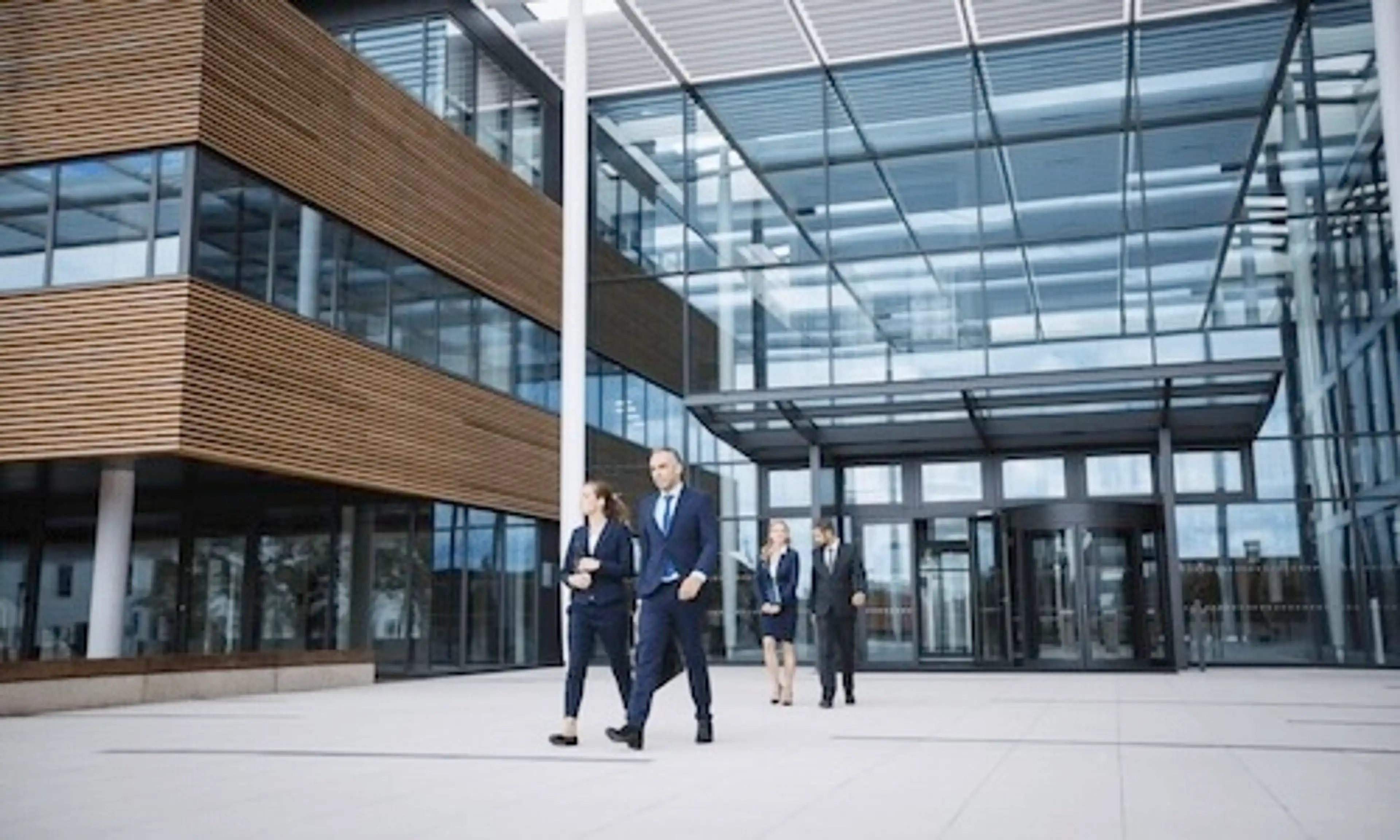 Four people walking in front of a commercial building