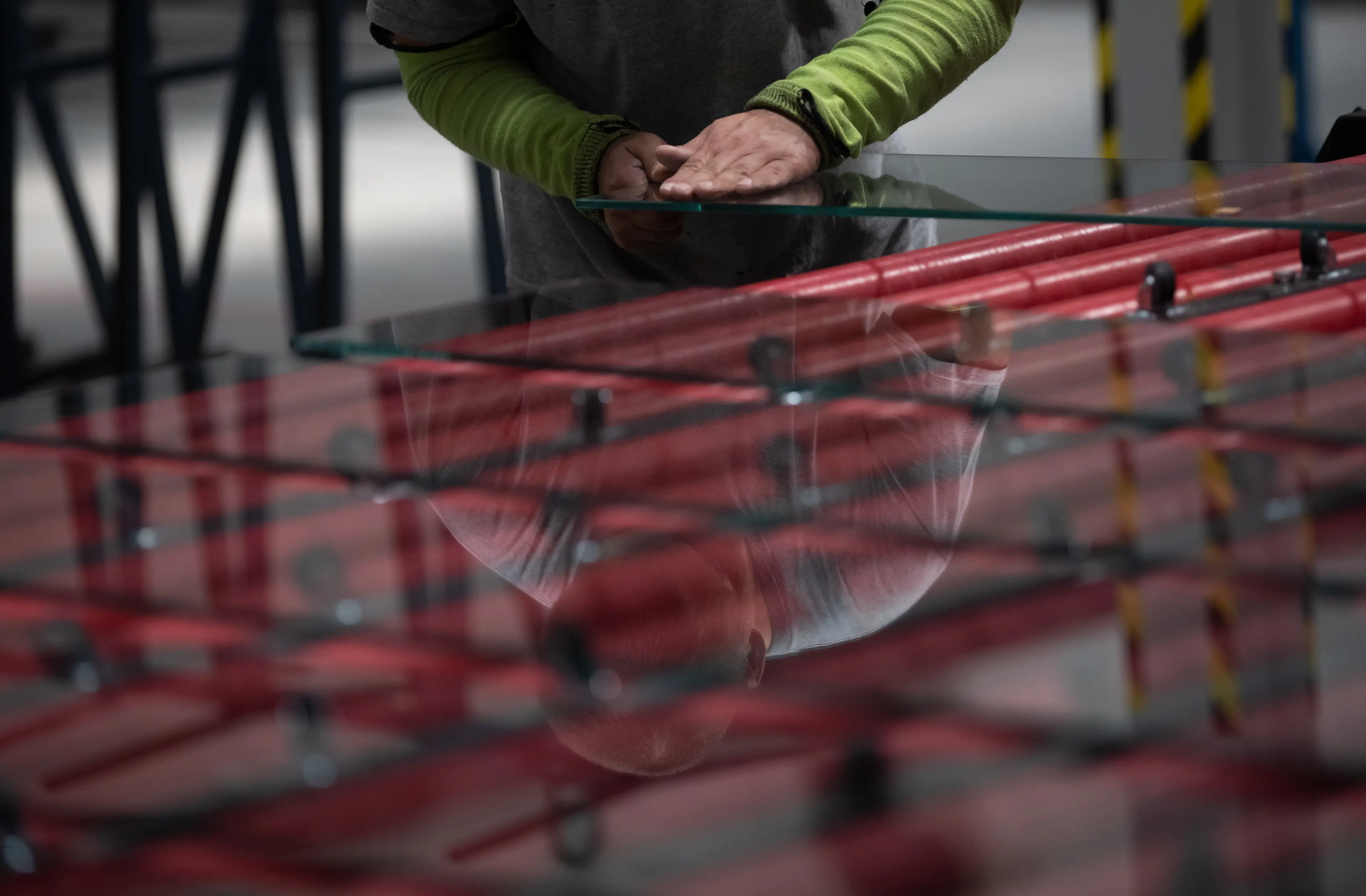 A man is inspecting a piece of glass