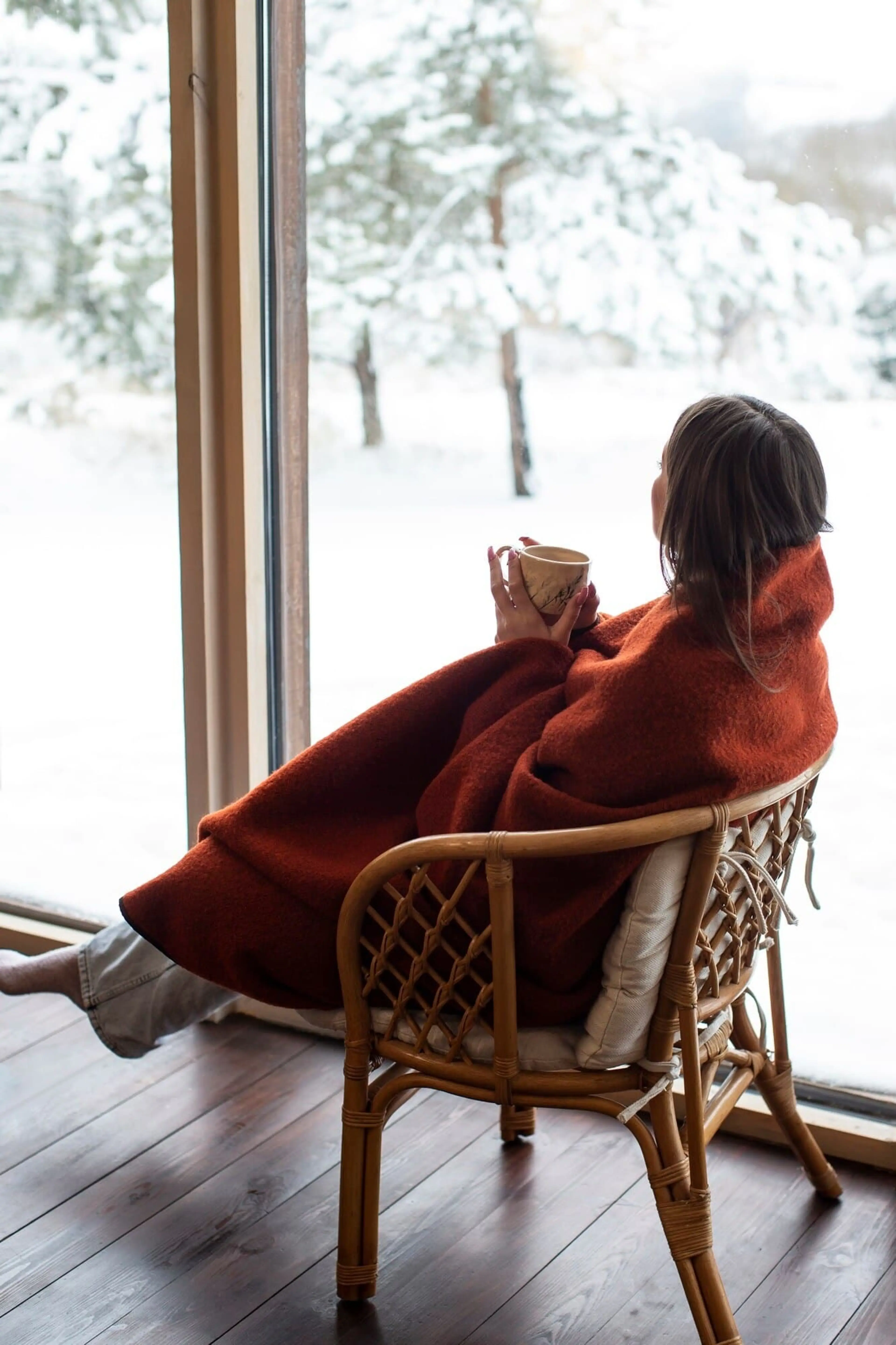 A lady is sitting in a cozy living room