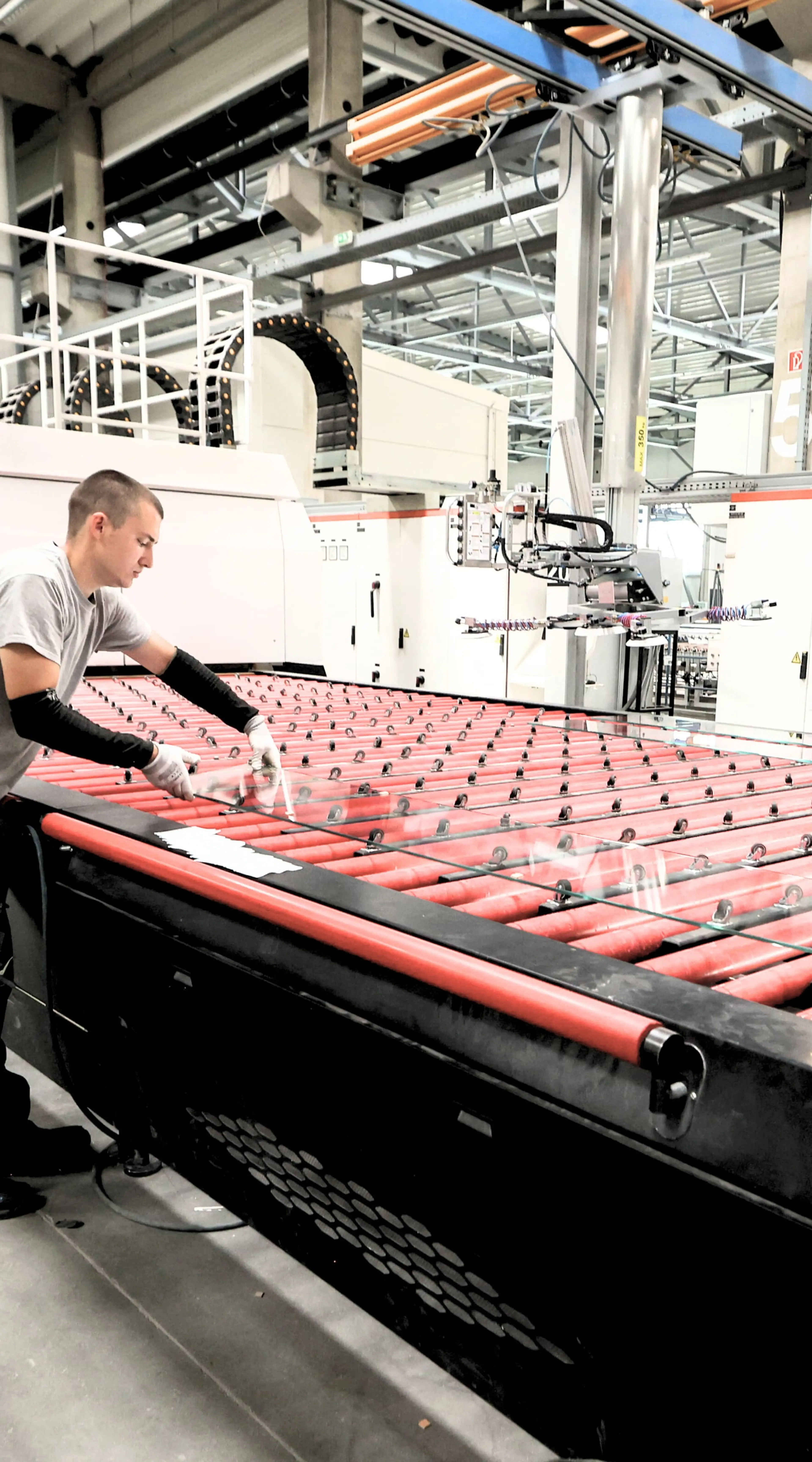 Two men operate a machine for making tempered glass