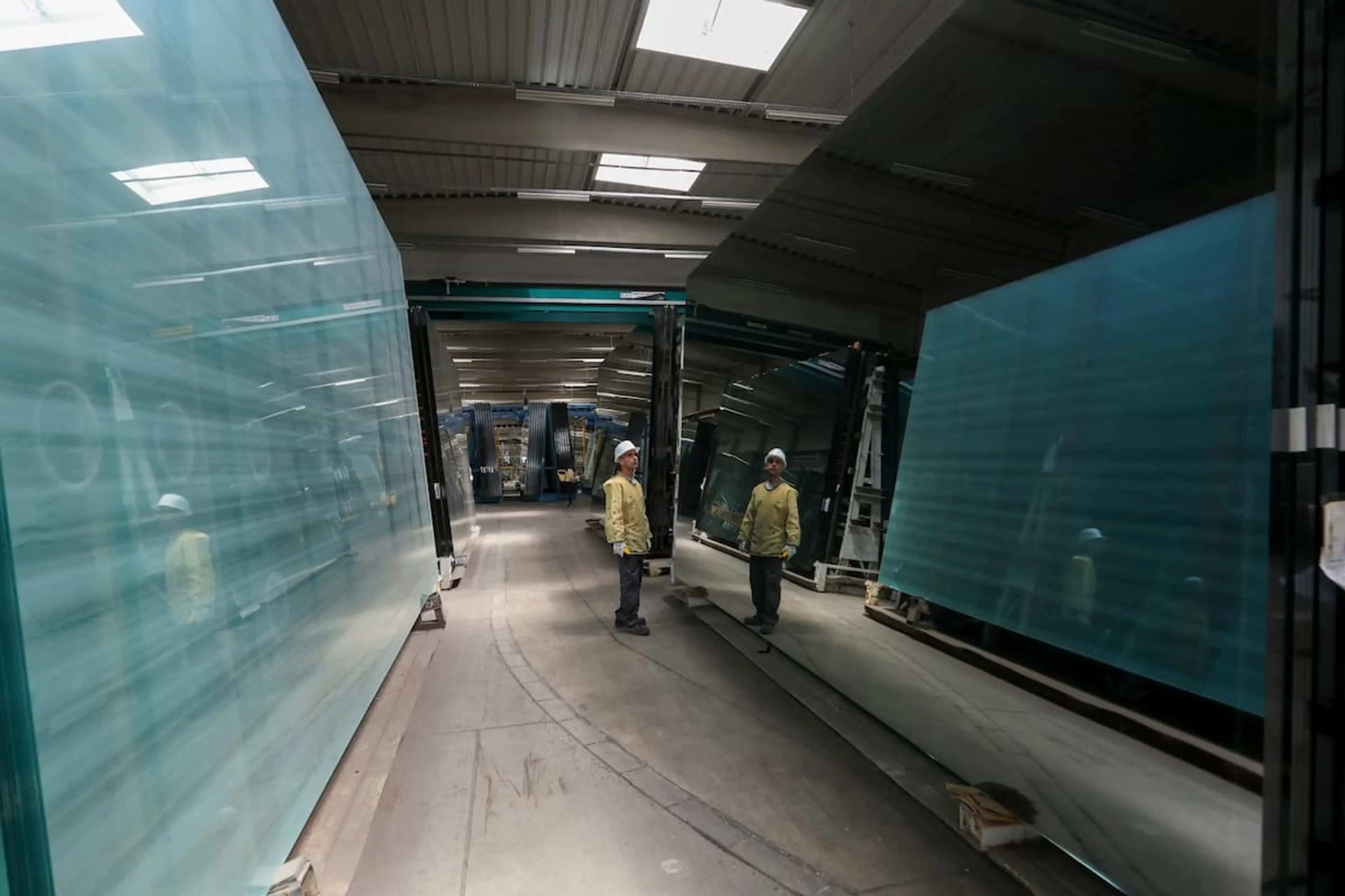 A man is inspecting a piece of glass