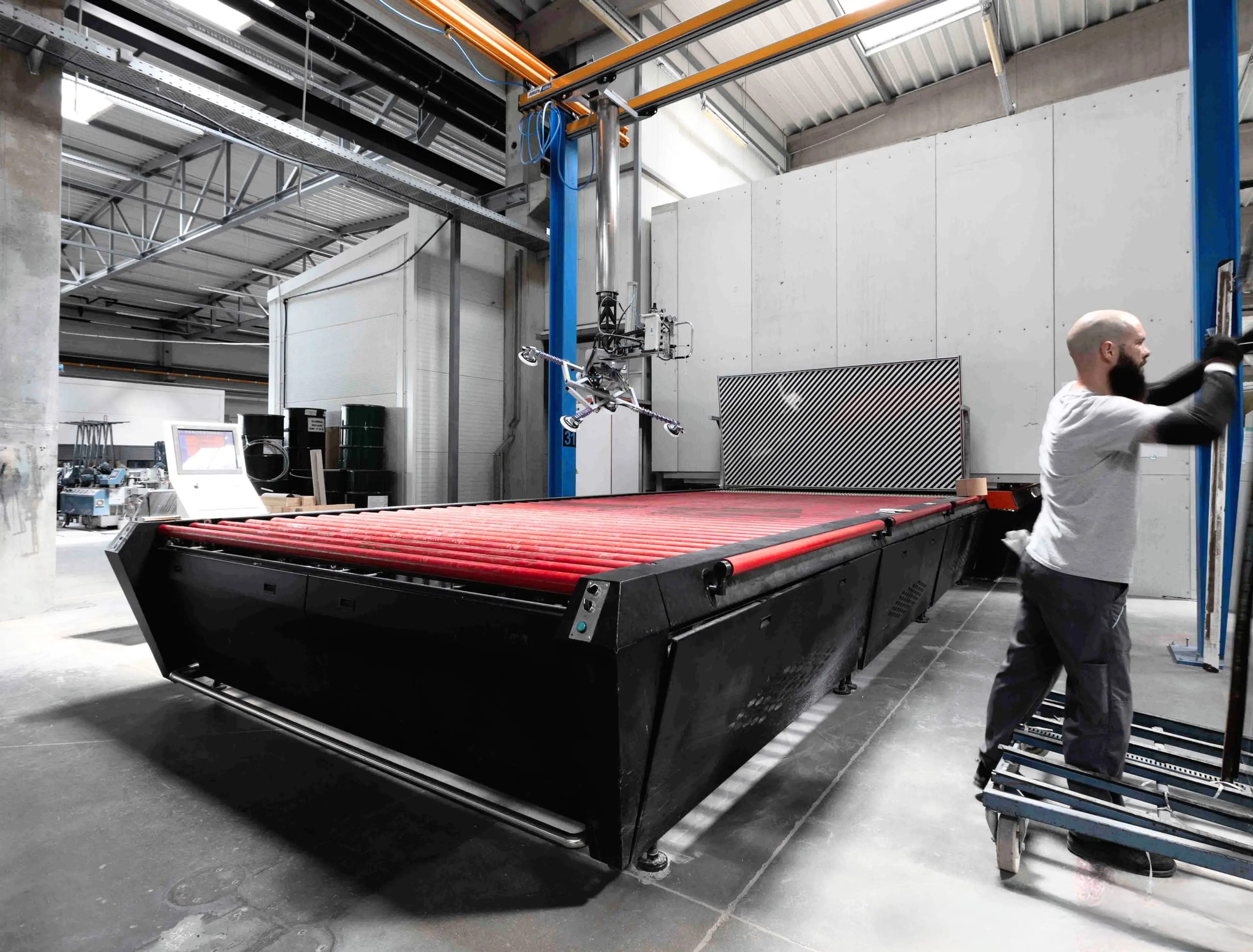 A man is handling a glass tempering machine