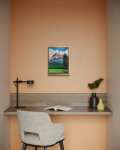 a painting of a mountain above a desk with a chair