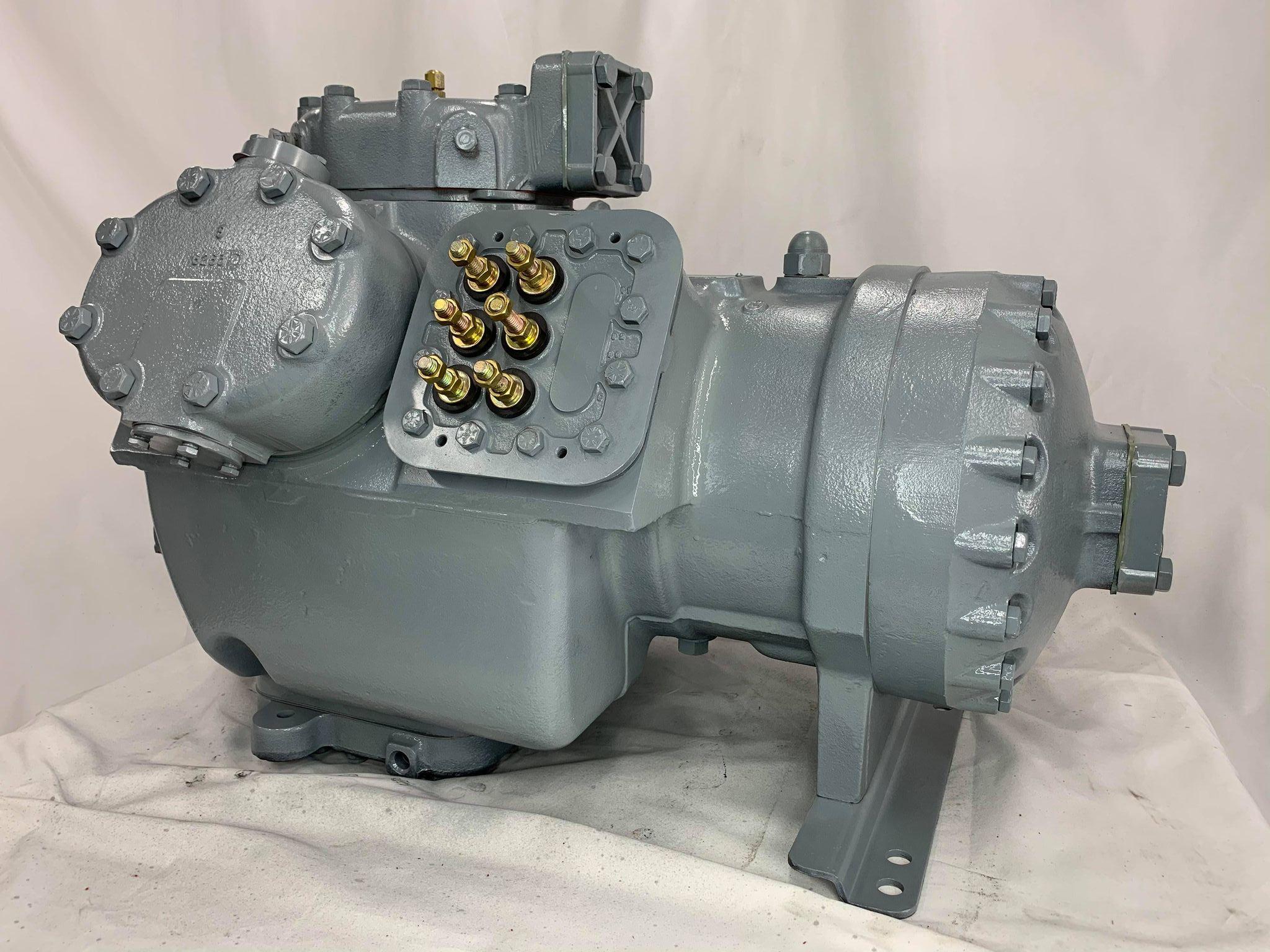 Remanufactured Carrier 06E semi-hermetic reciprocating compressor with visible fittings and connections.