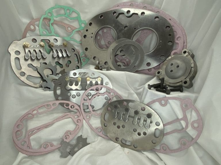 Assorted Carrier valve plates and gaskets for semi-hermetic compressors.