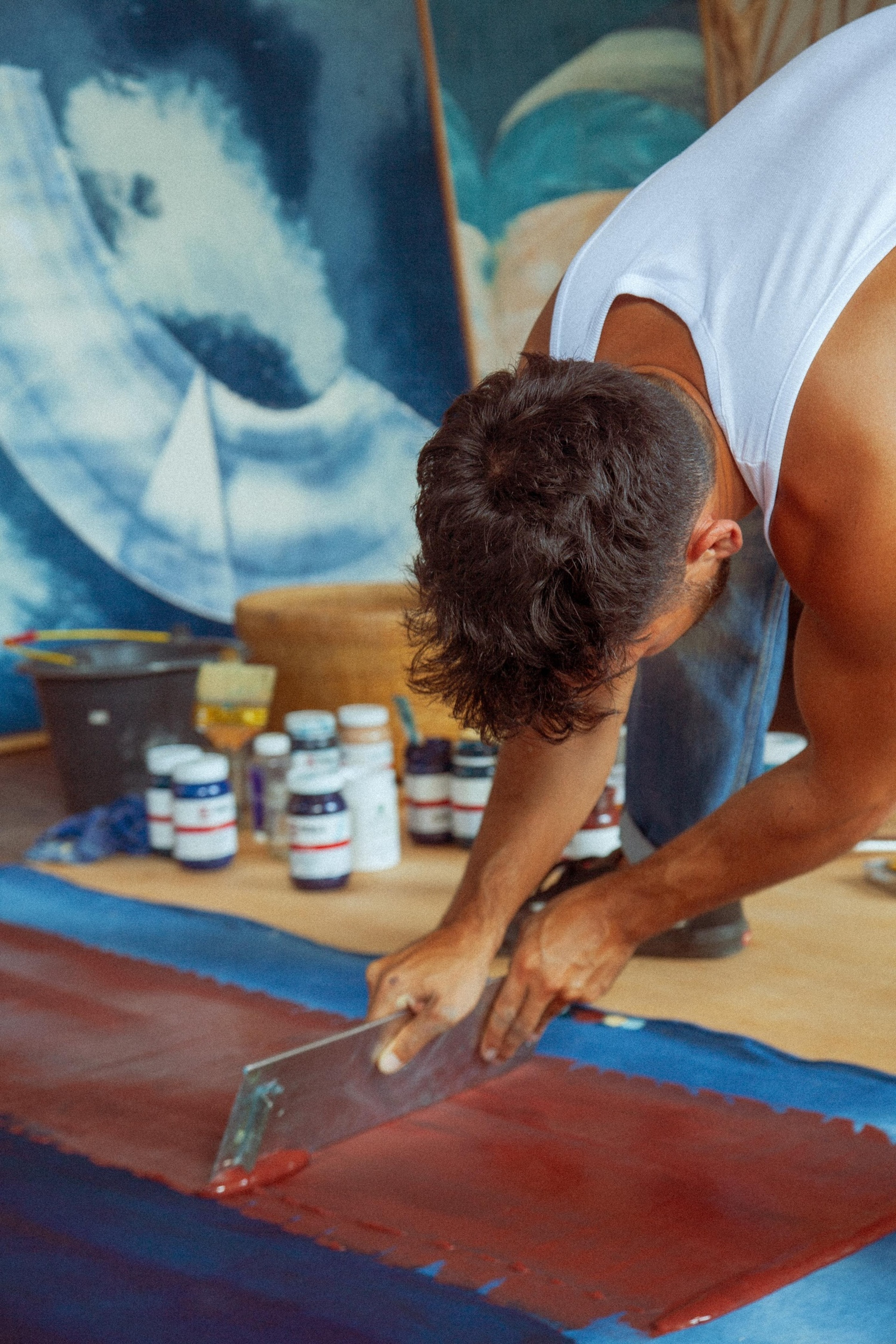Jake Paul White painting an abstract indigo painting with natural dyes on canvas, close up, in his Bali studio