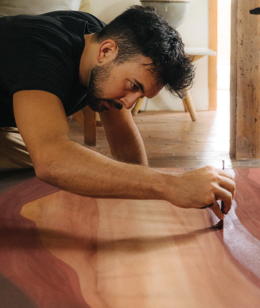 Jake Paul White painting an abstract red painting with natural dyes and pigments on canvas, close up, in his Bali artist studio