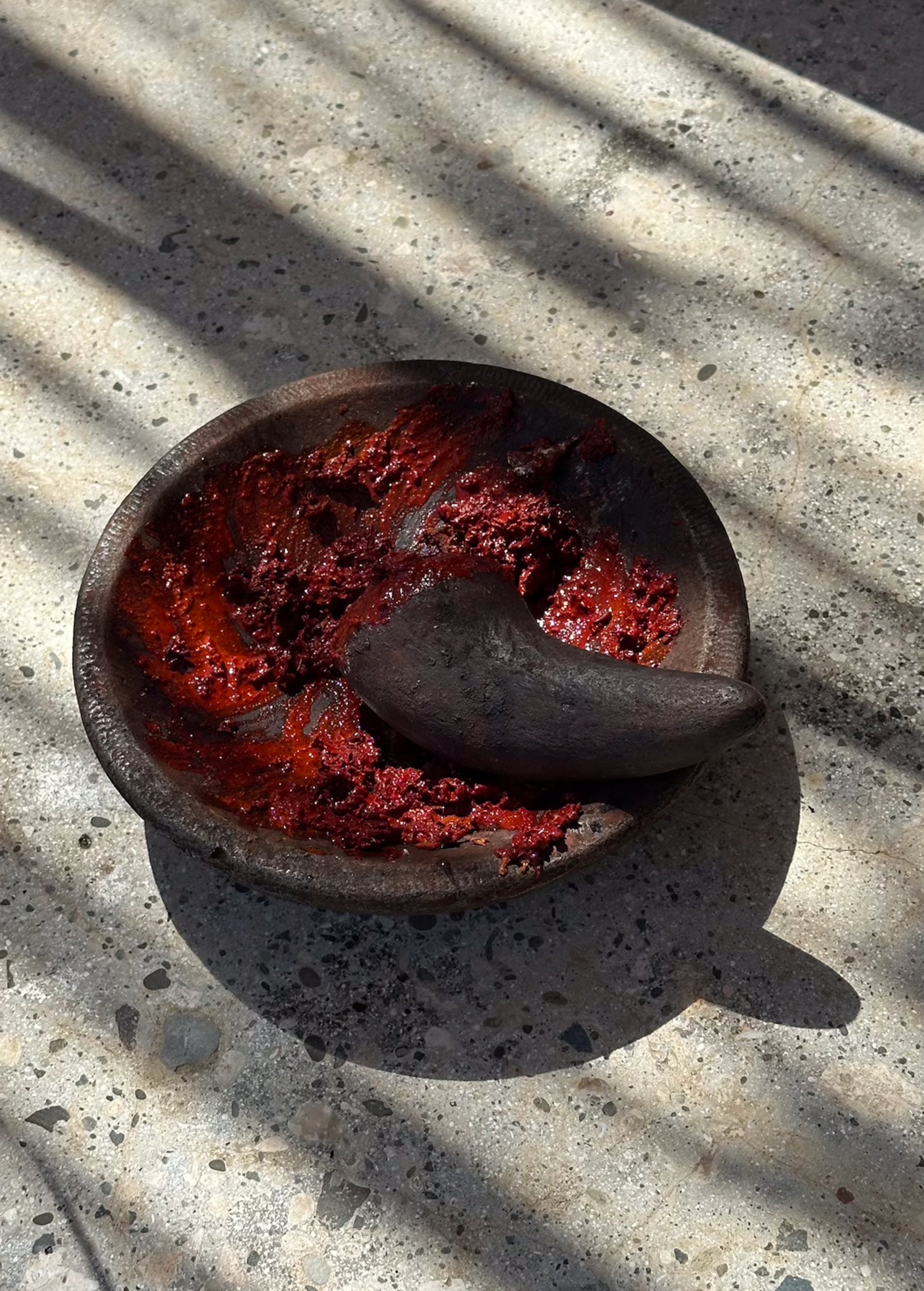 Stone mortar and pestle with red betel nut pigment, Sumba Image