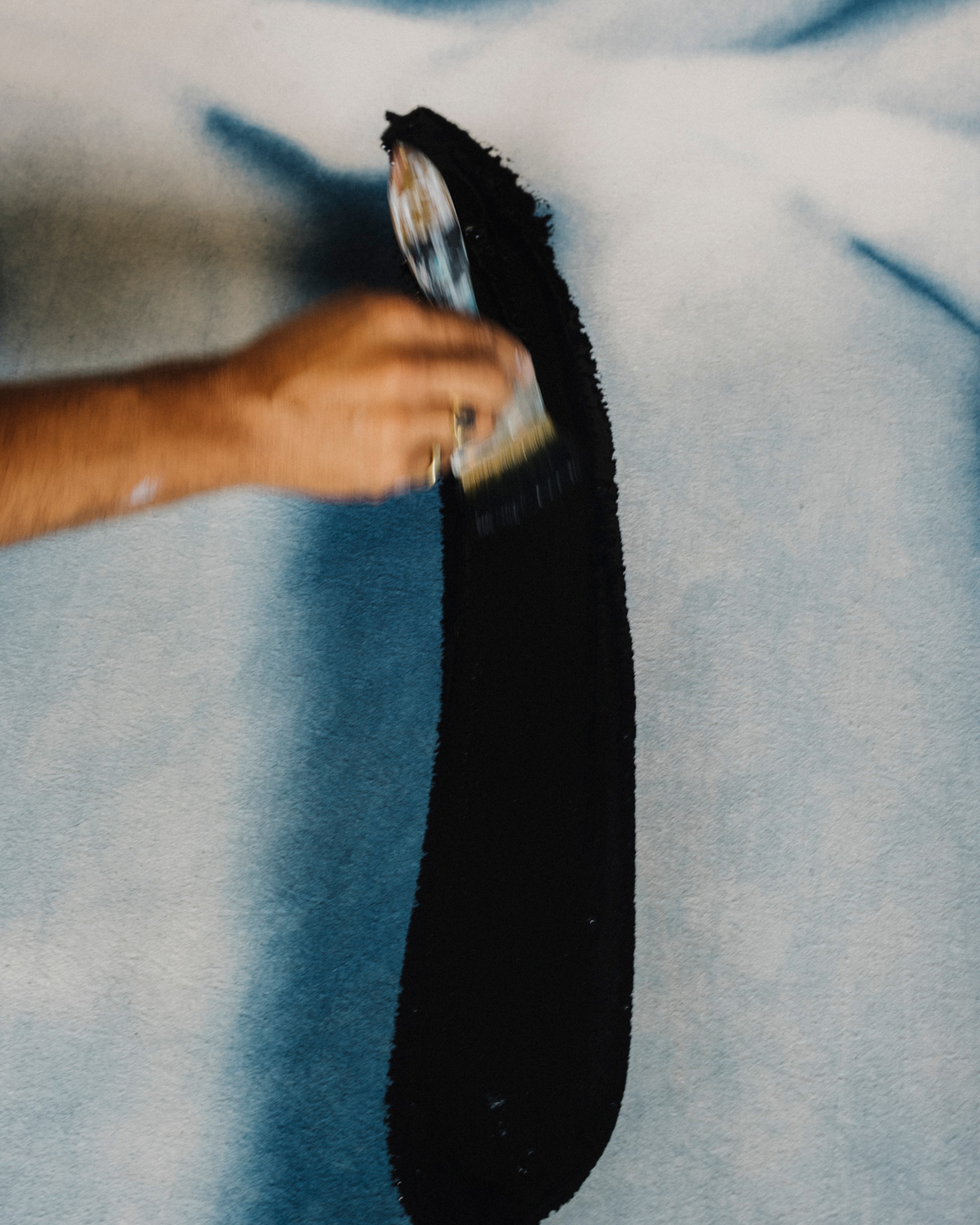 Jake Paul White painting an abstract indigo painting with natural dyes on canvas, close up, in his Bali studio