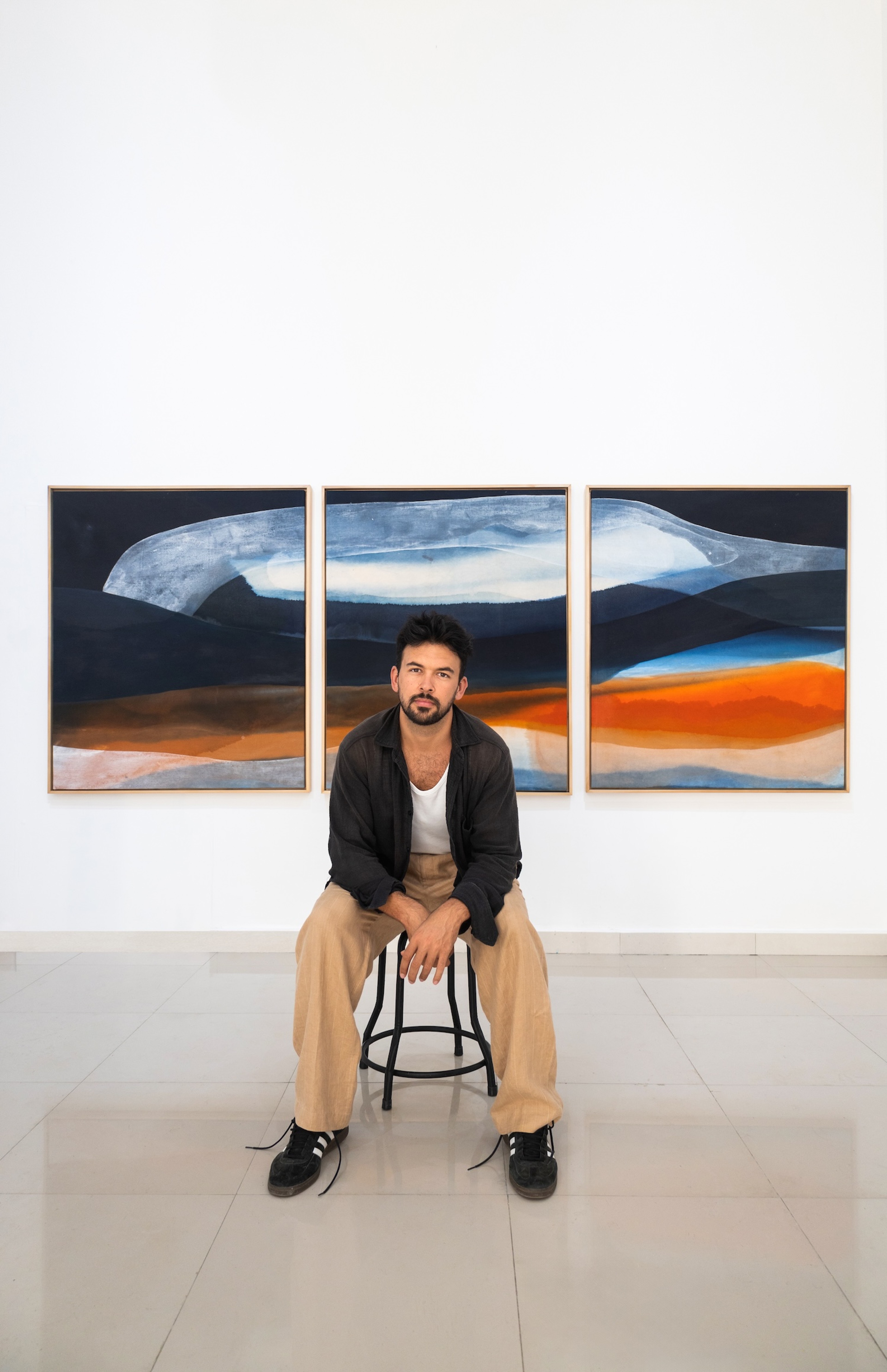 Jake Paul White siting infront of abstract painting made with natural indigo dyes