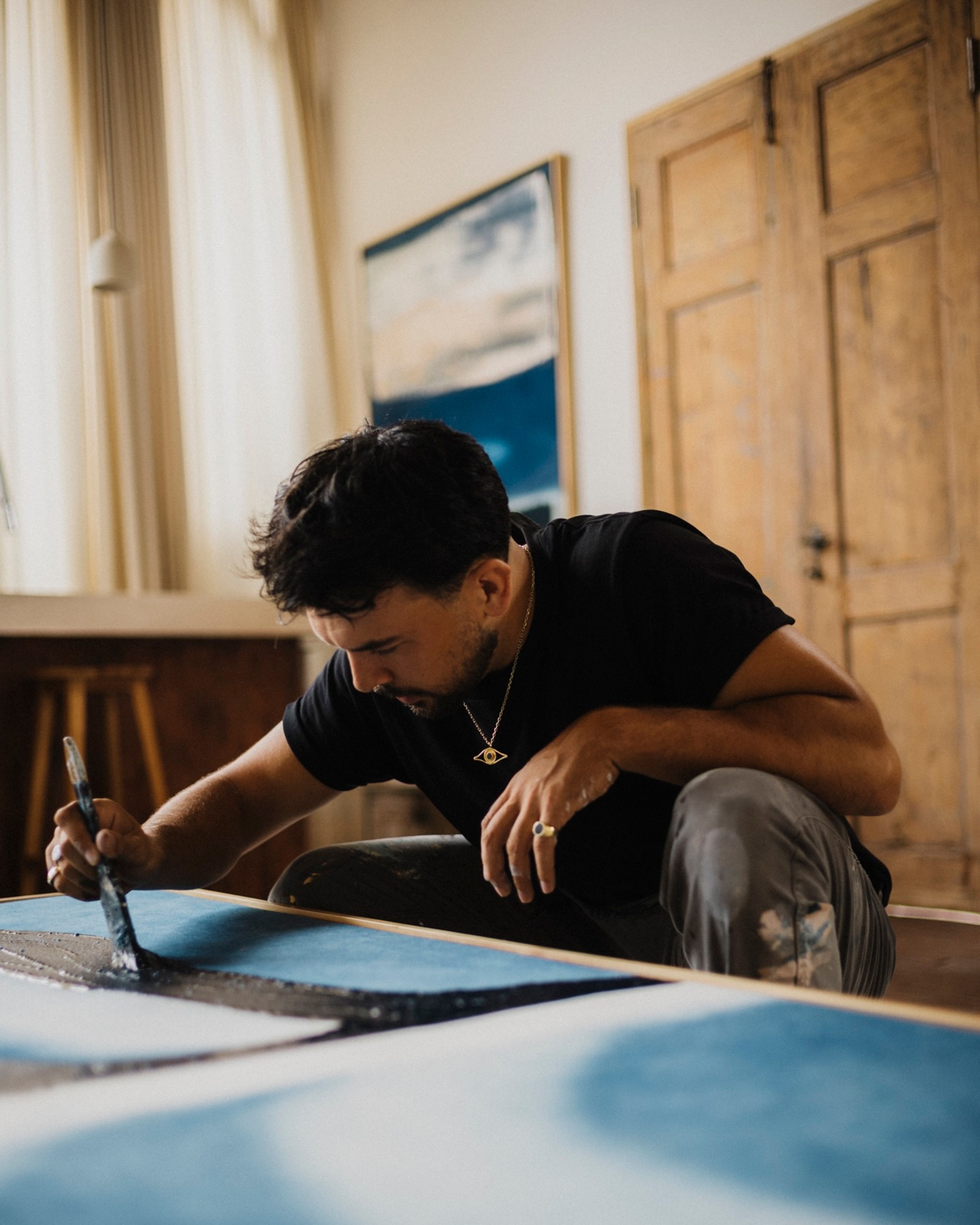 Jake Paul White painting an abstract indigo painting with natural dyes on canvas, close up, in his Bali artist studio