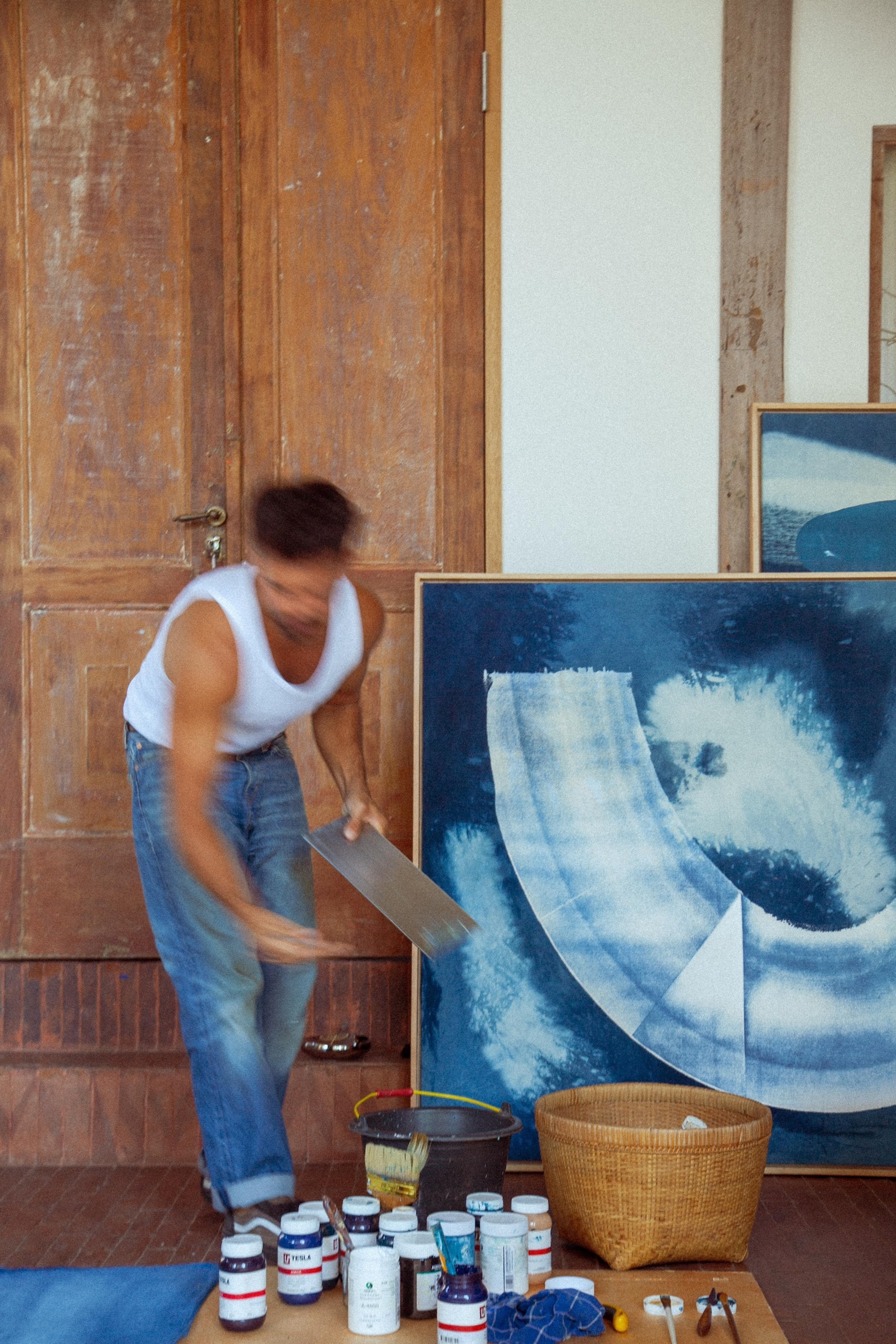 Jake Paul White painting an abstract indigo painting with natural dyes on canvas, close up, in his Bali artist studio