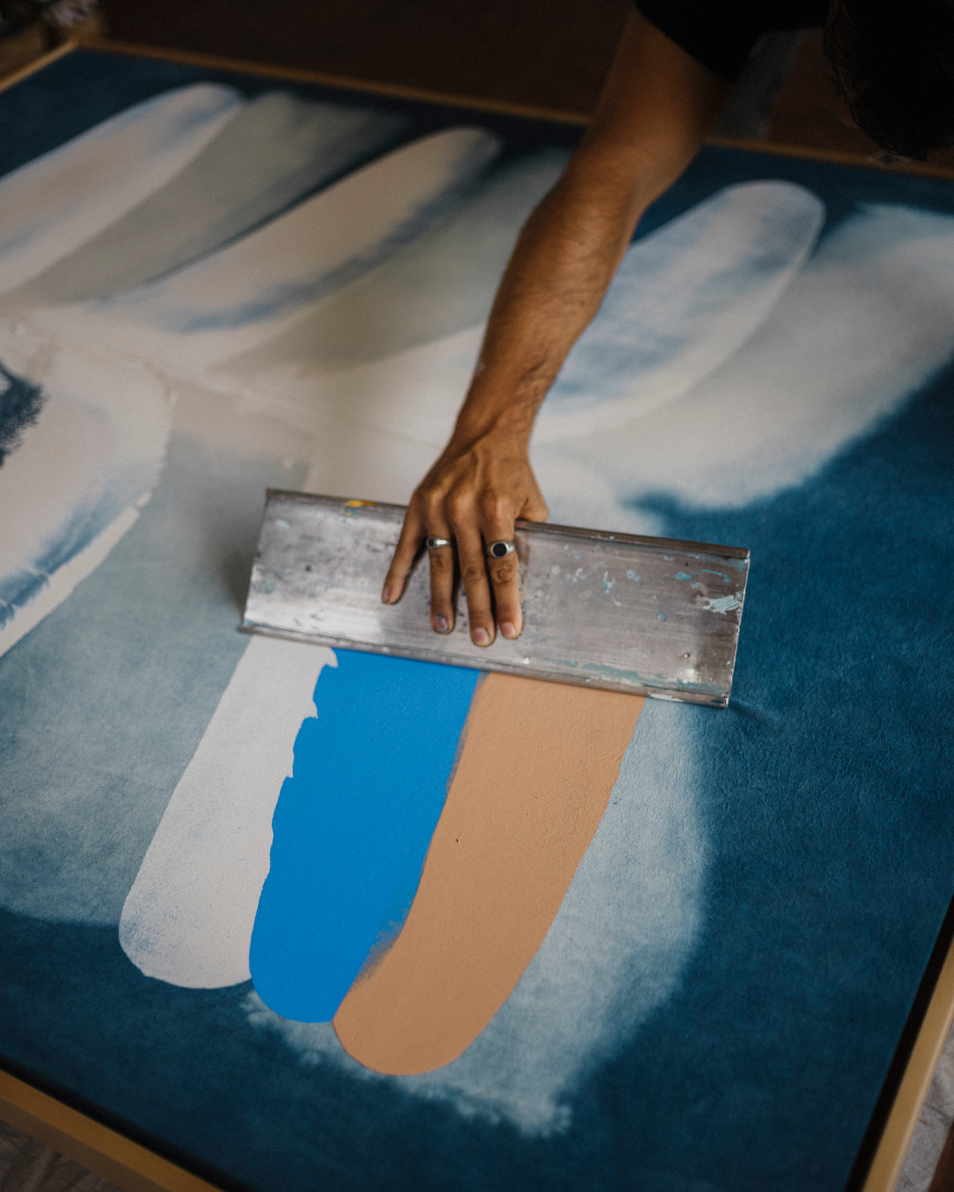 Jake Paul White painting an abstract indigo painting with natural dyes on canvas, close up, in his Bali studio