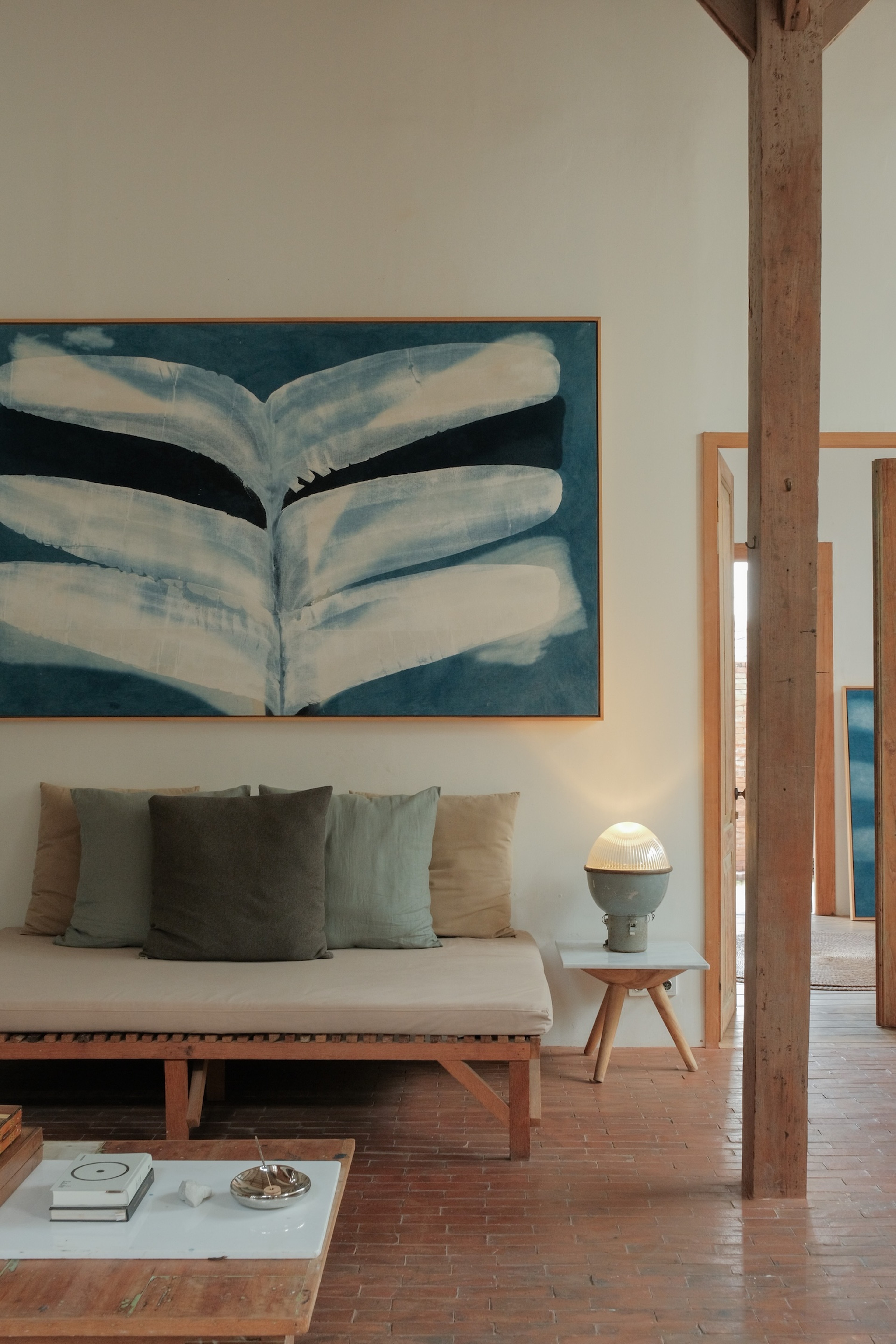 Abstract indigo painting with flowing organic forms by Jake Paul White, natural pigment on canvas, hung in an artist loft That Girl Retreat
