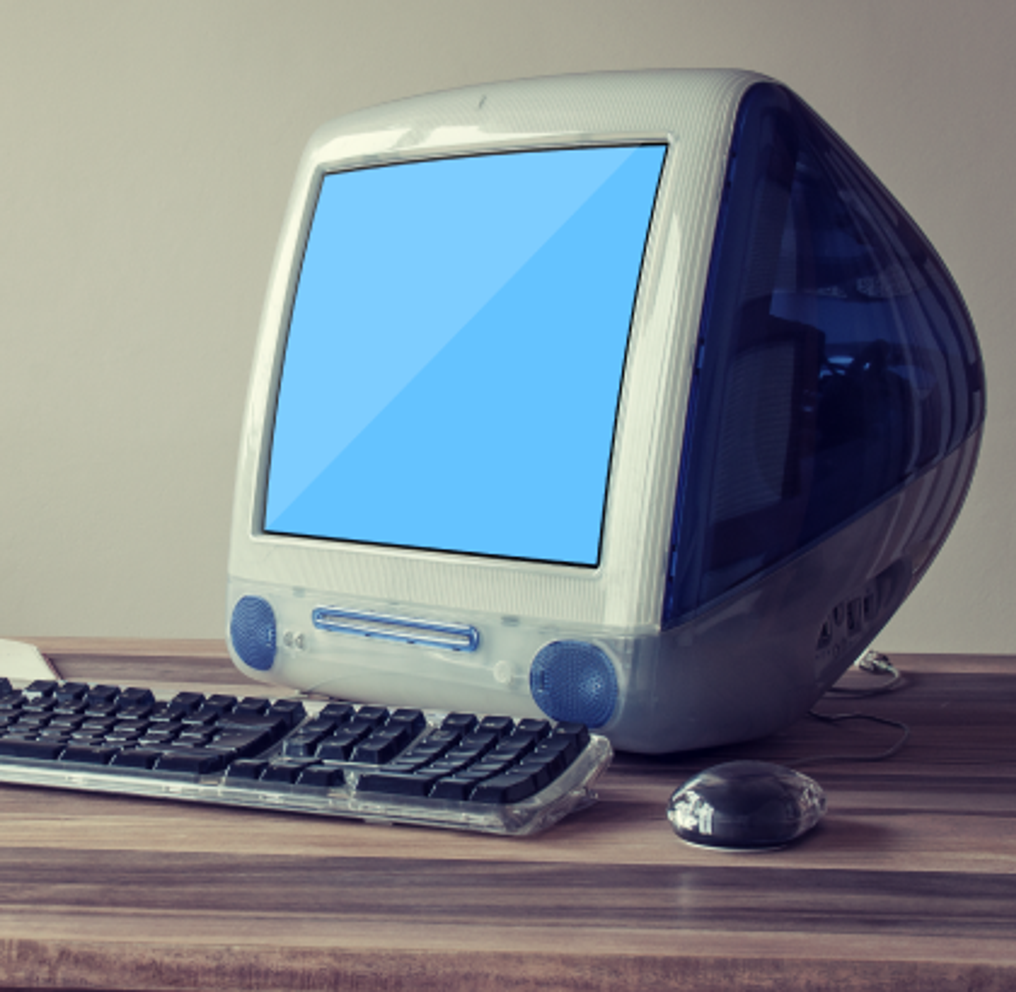 Old mac computer in blue with a keyboard and mouse