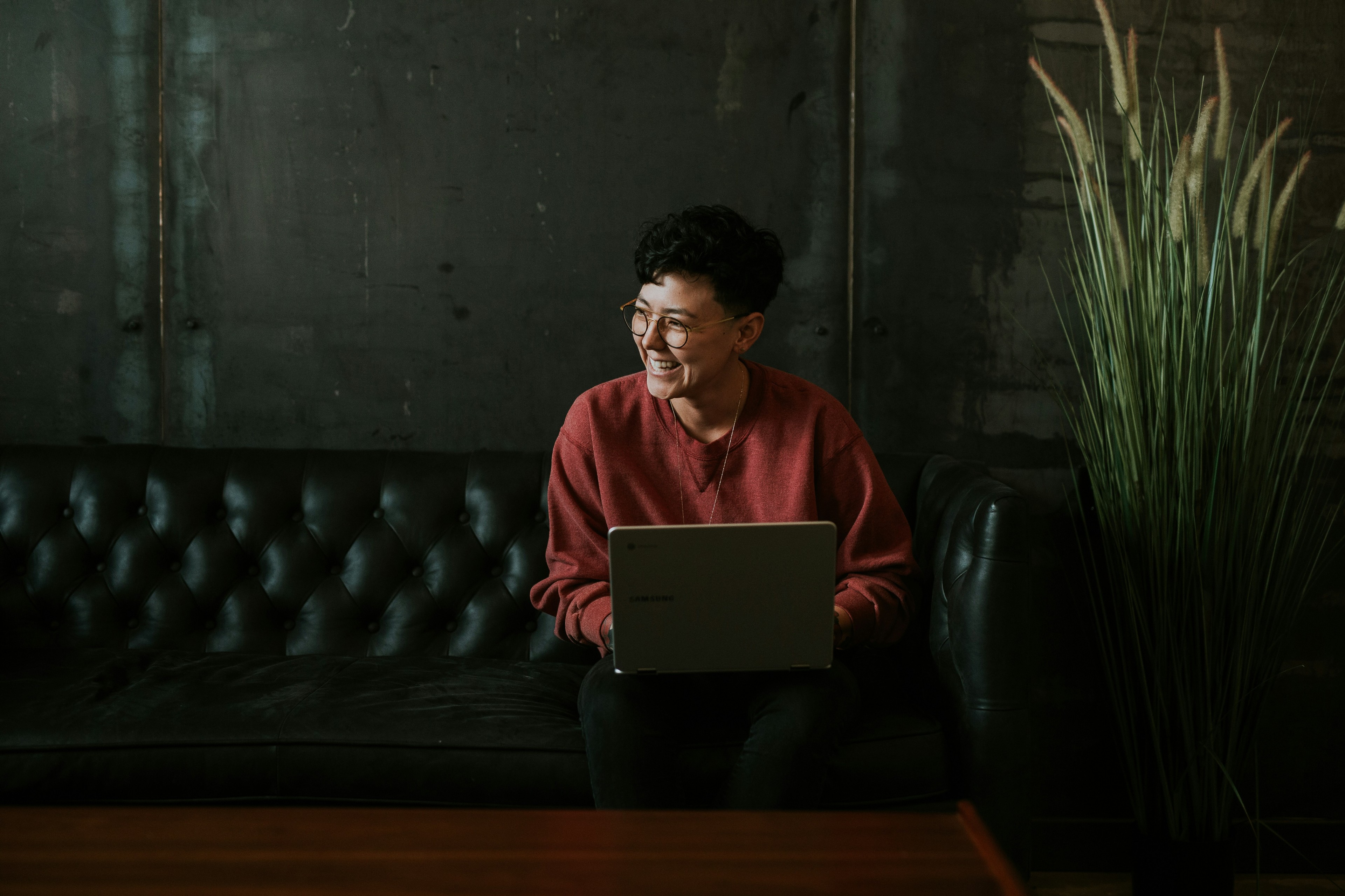 Person working from laptop on a stately leather sofa in a building lobby