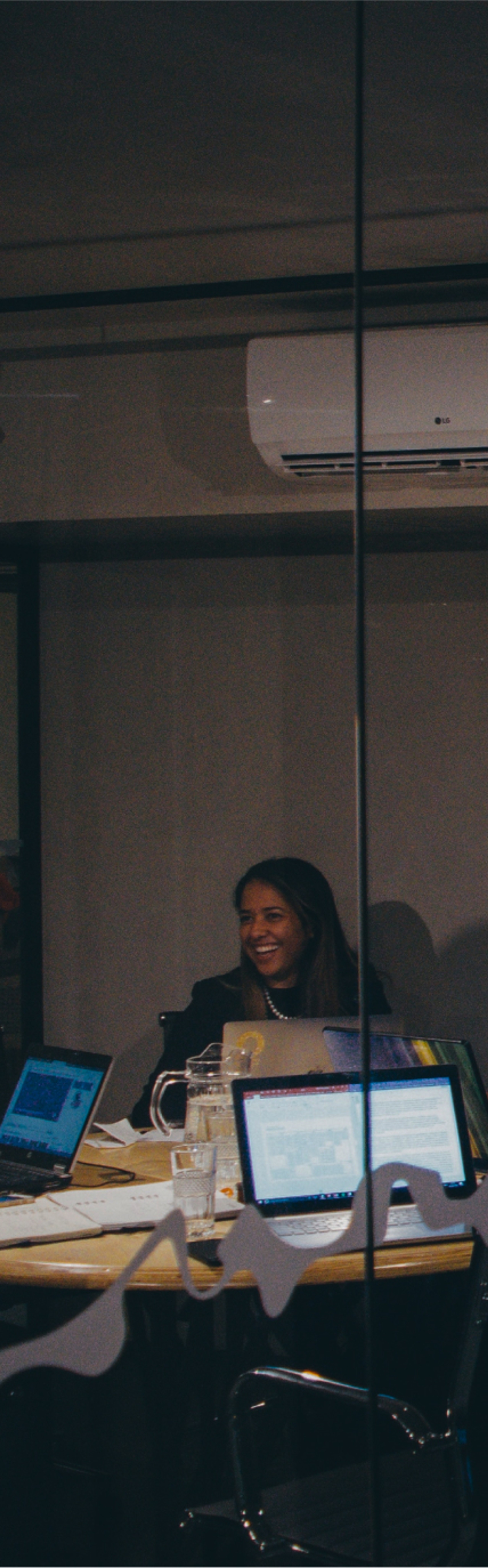 View of a woman smiling through glass in an office