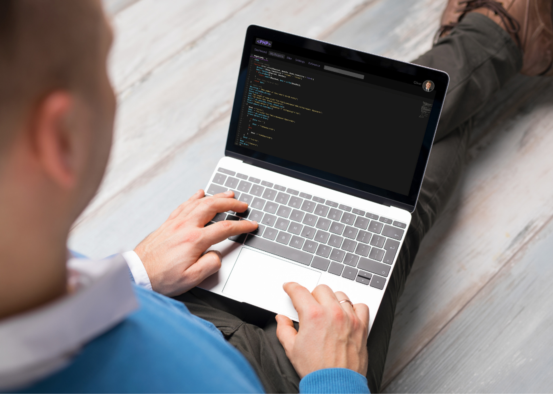 Man writing code on a laptop