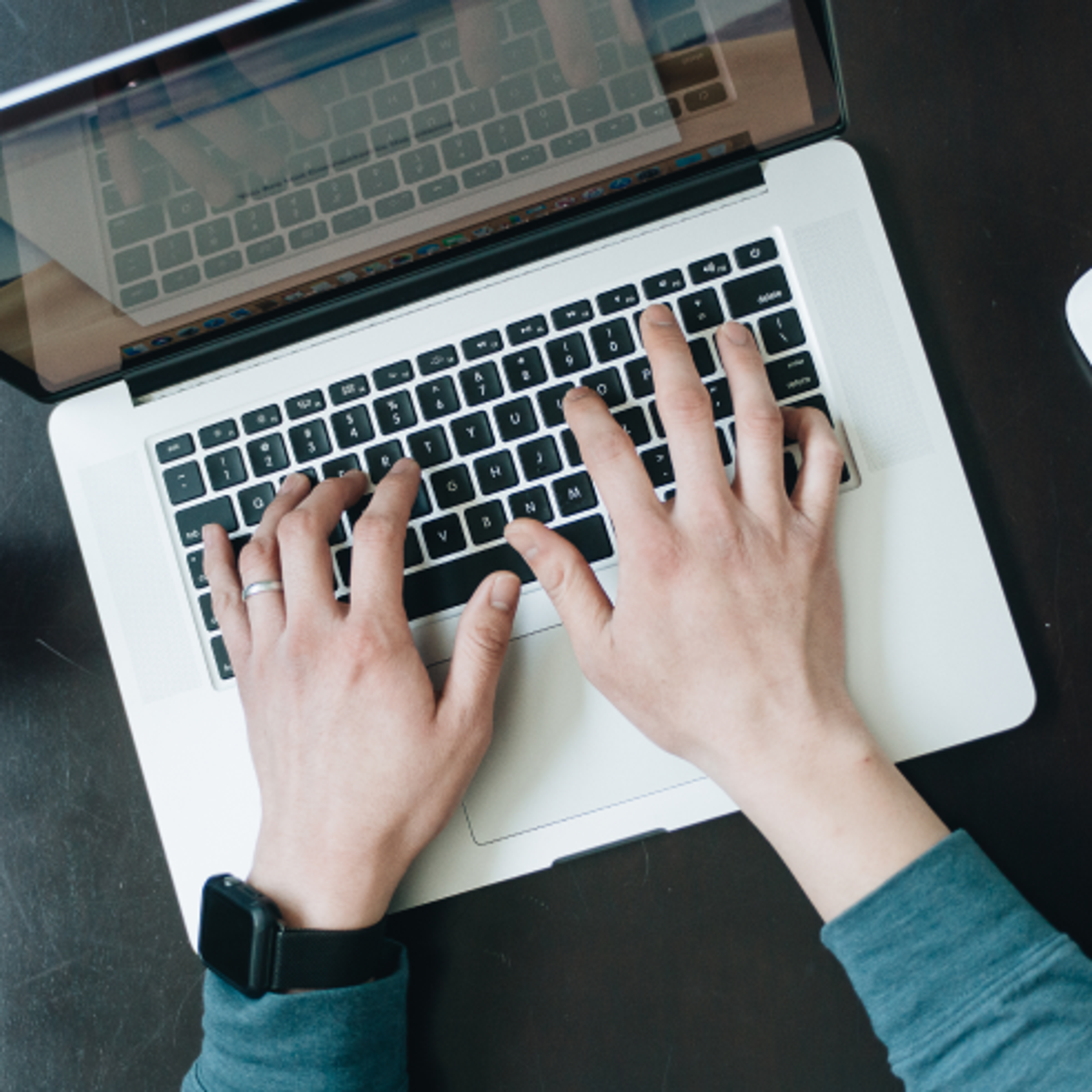 Overhead shot of a person typing on a laptop