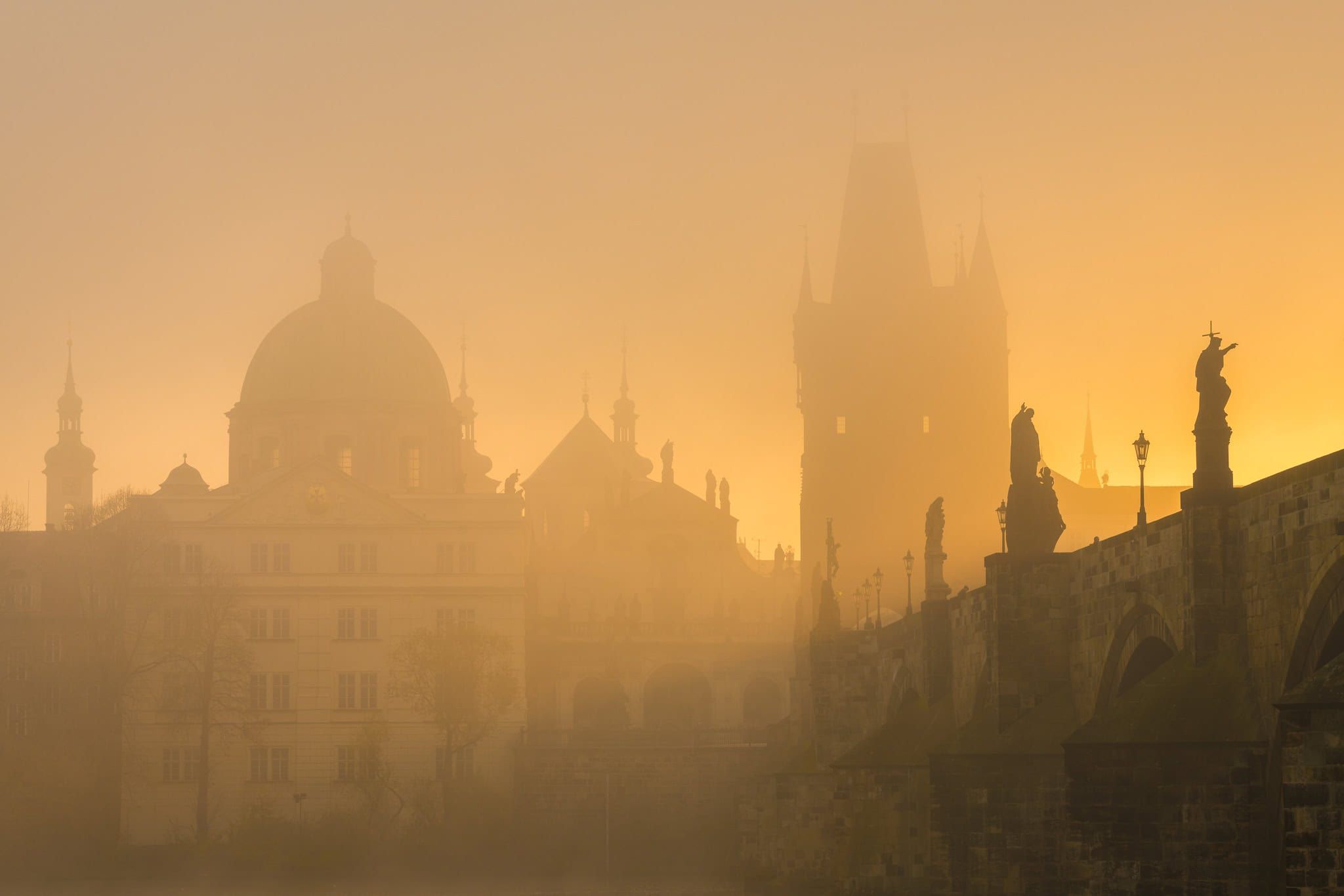 Charles Bridge in morning fog at sunrise, Prague, Czech Republic