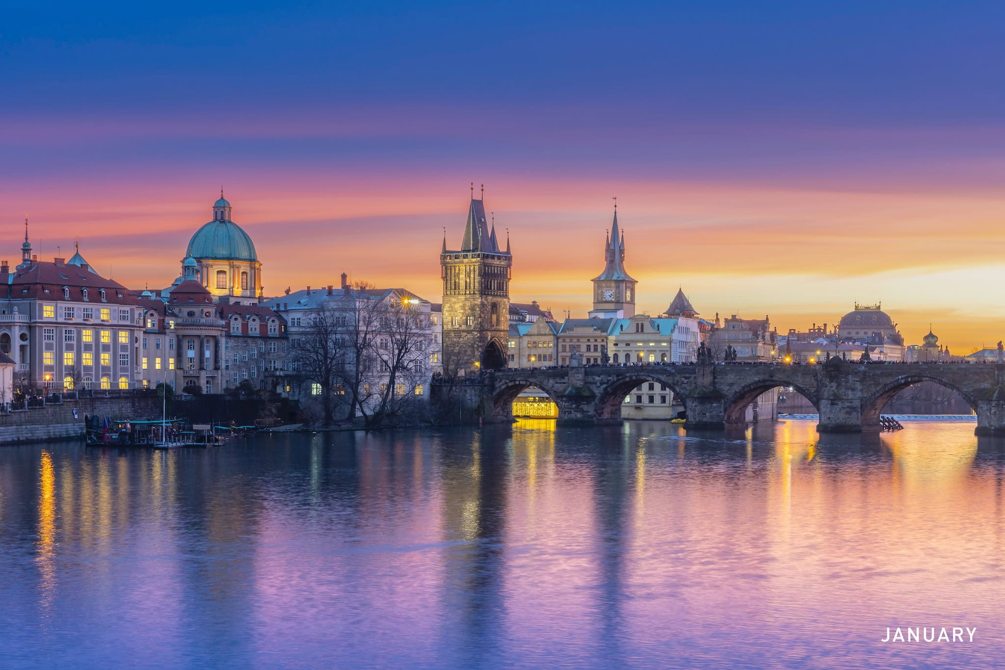 January: Charles Bridge and the Old Town skyline at sunset over the Vltava, Prague, Czech Republic