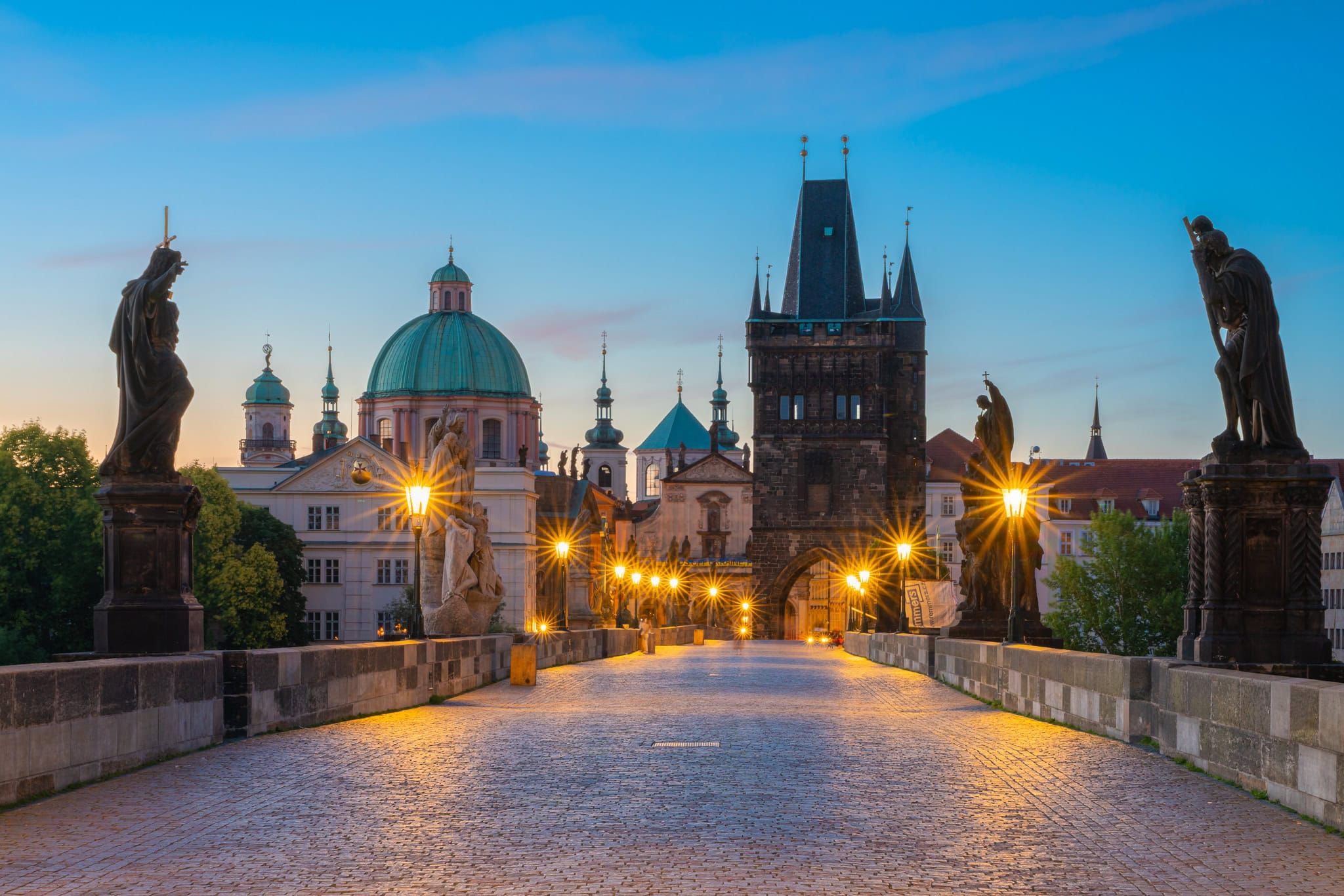 Charles Bridge at dawn with street lamps illuminated, Prague, Czech Republic