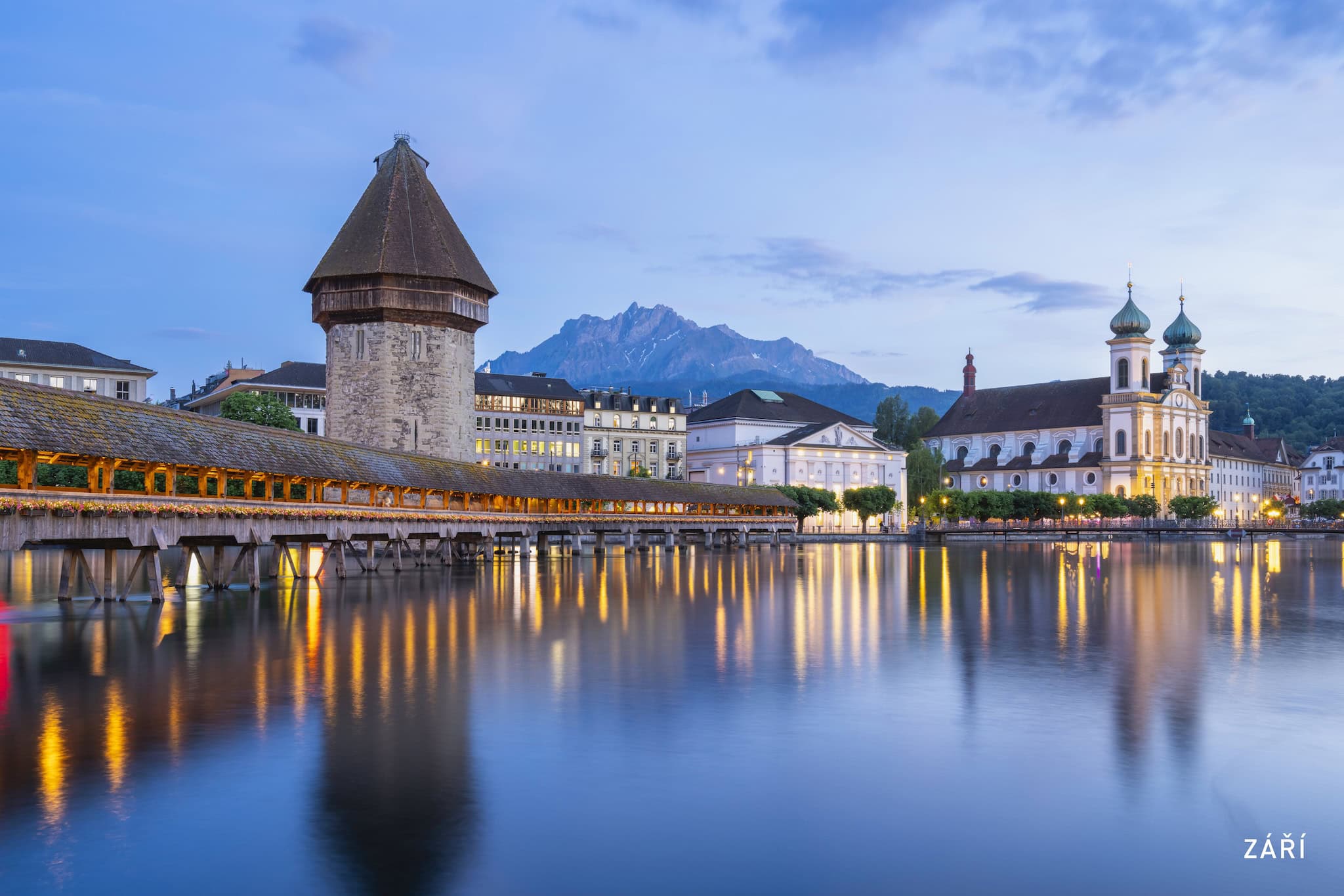 Září: Kaplový most a vodárenská věž na řece Reuss za soumraku, Lucern, Švýcarsko