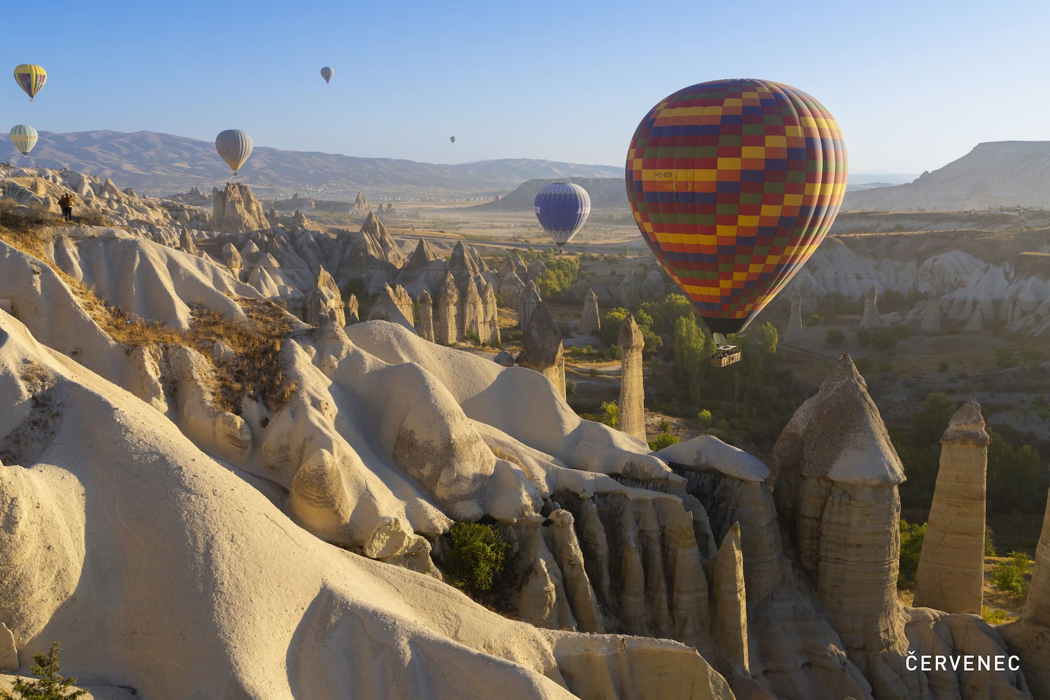 Červenec: horkovzdušné balony nad skalními útvary Kappadokie, Göreme, Turecko
