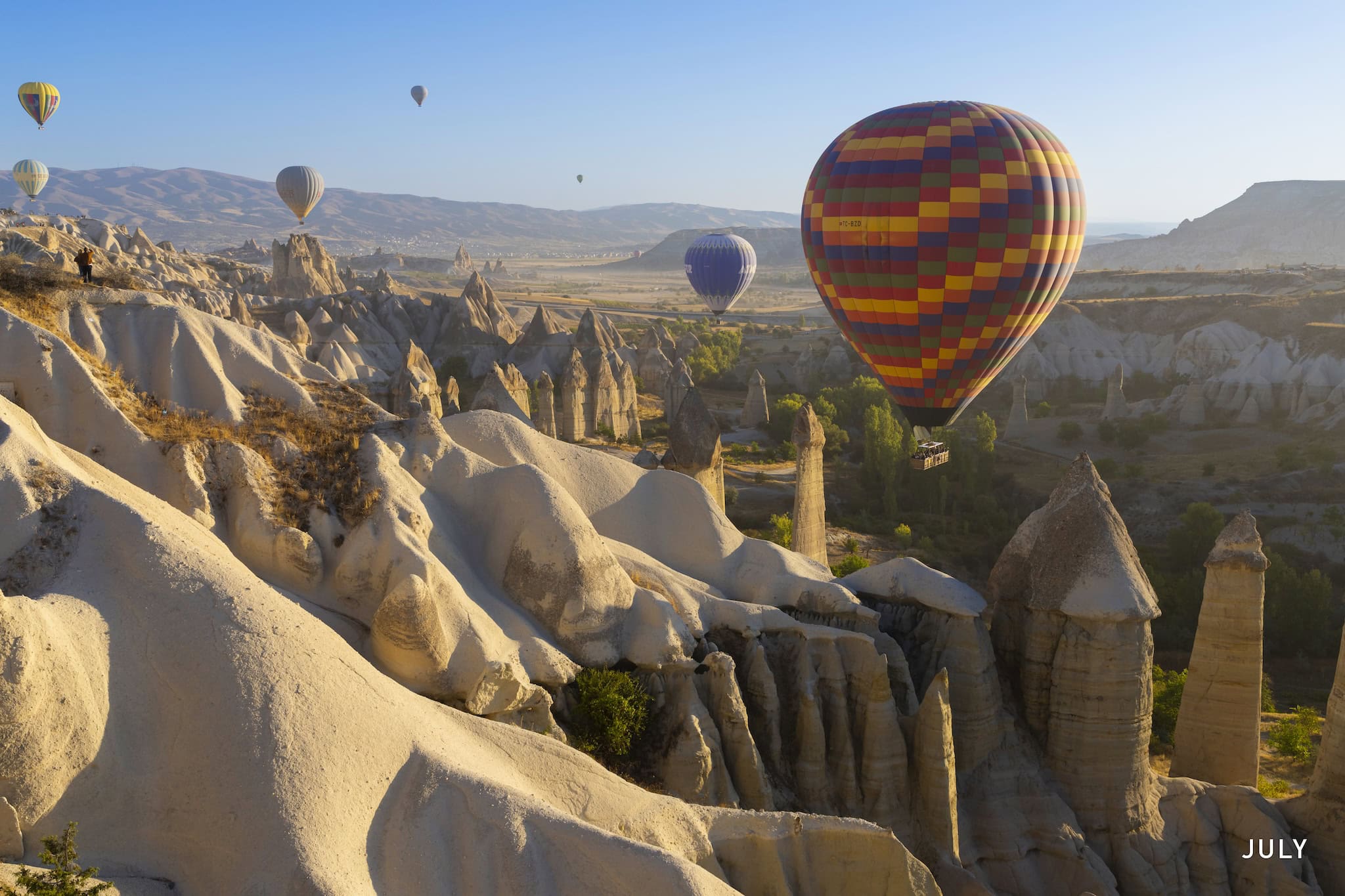 July: Hot-air balloons above the rock formations of Cappadocia, Göreme, Türkiye