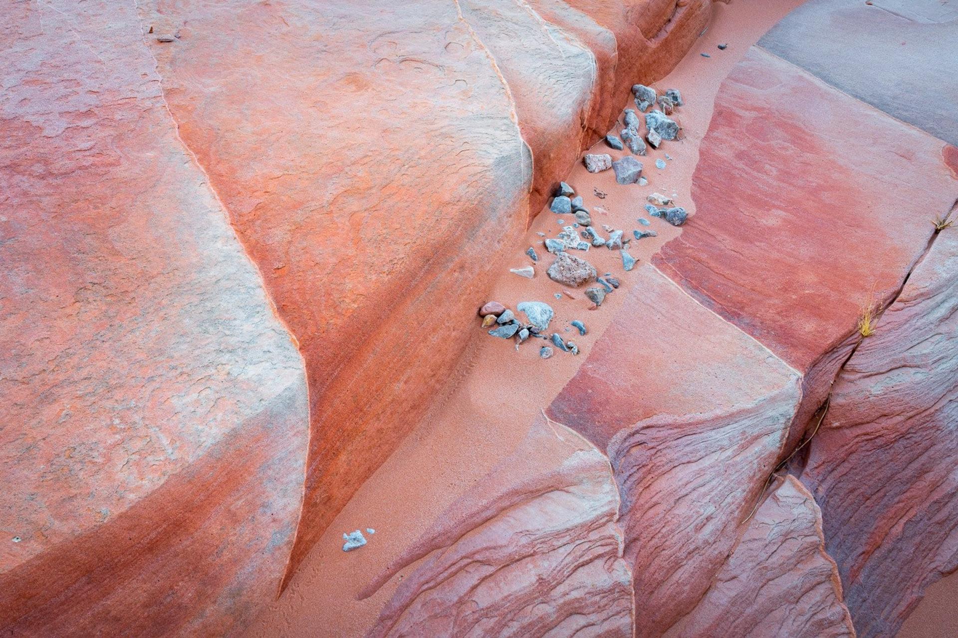 Layered red sandstone formations with scattered rocks, American Southwest
