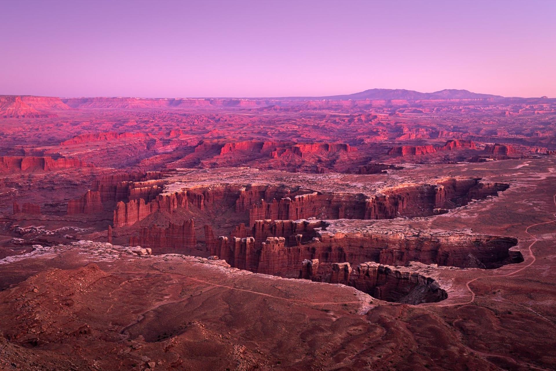 Red rock formations and mesas stretching across desert landscape at sunset, American Southwest.
