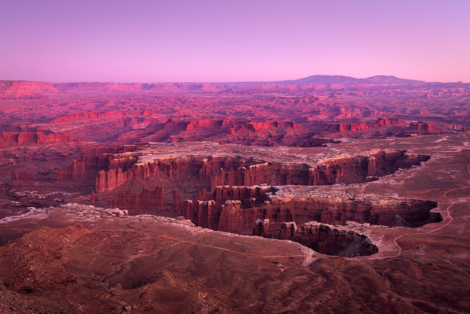 Red rock formations and mesas stretching across desert landscape at sunset, American Southwest.