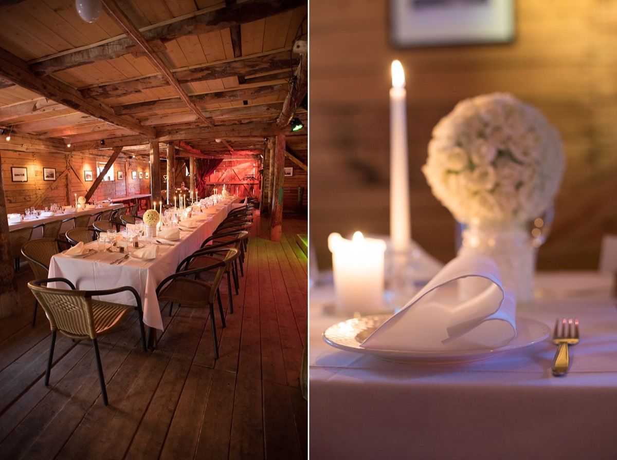 Langbord pyntet til bryllup med hvite duker, levende lys og blomsteroppsatser i historiske lokaler