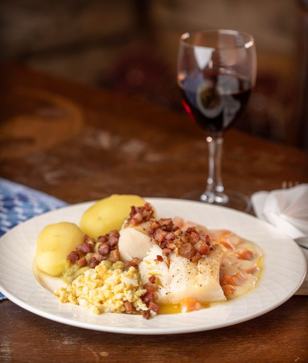 Anrettet torsk med baconterninger, poteter, eggerøre og rødvin