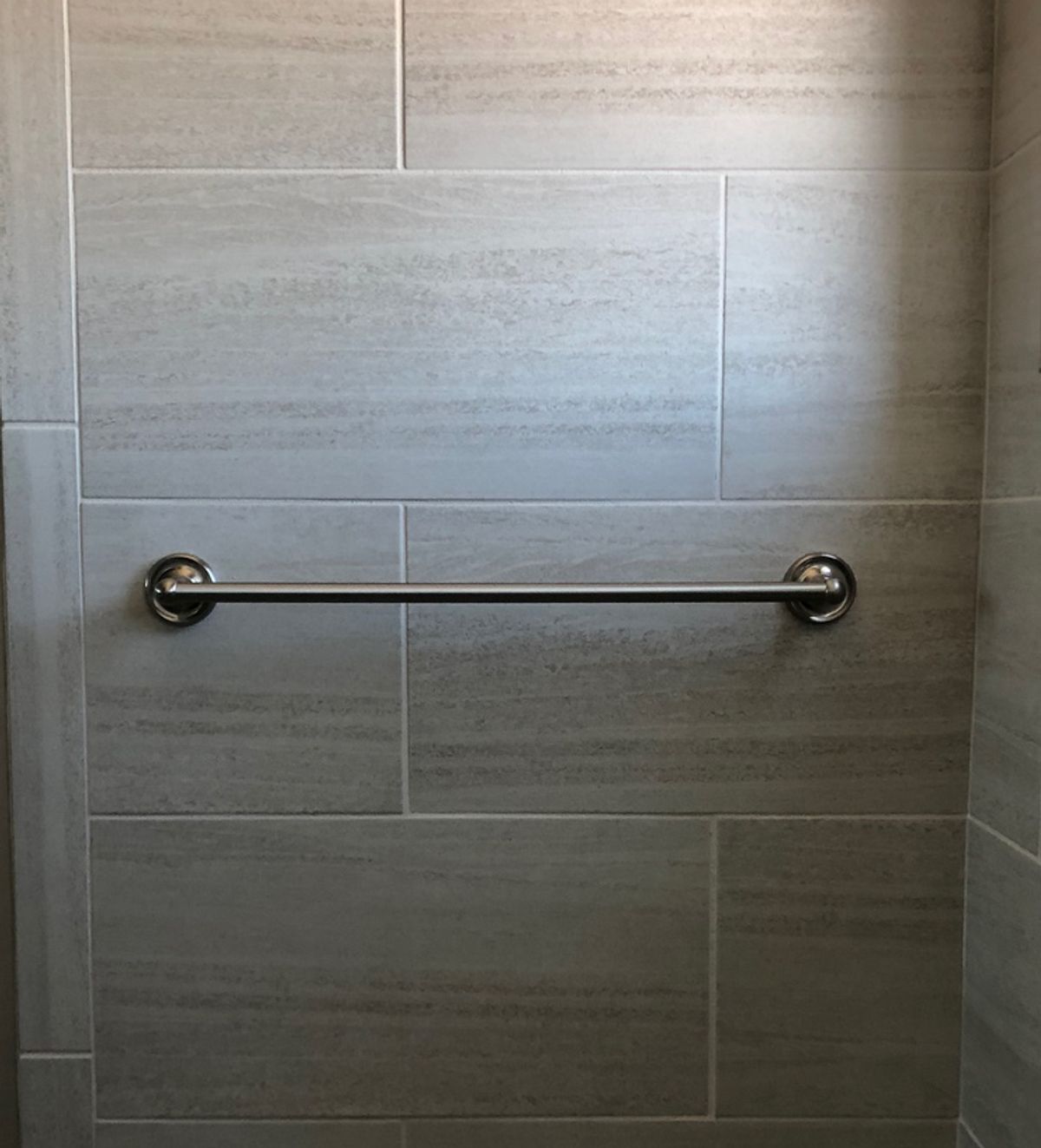 Tiled shower wall and grab bar in a MyColorSeal restoration example