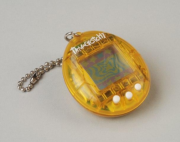 A translucent yellow Tamagotchi lies on a white surface
