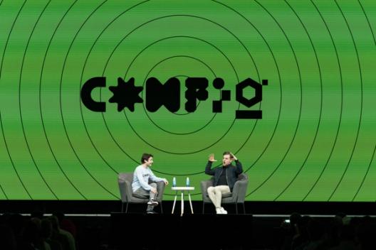 Dylan Field and Brian Chesky sitting in chairs on stage with the Config logomark behind them on a green background
