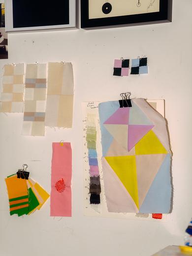 A photograph of fabric swatches pinned to the wall.