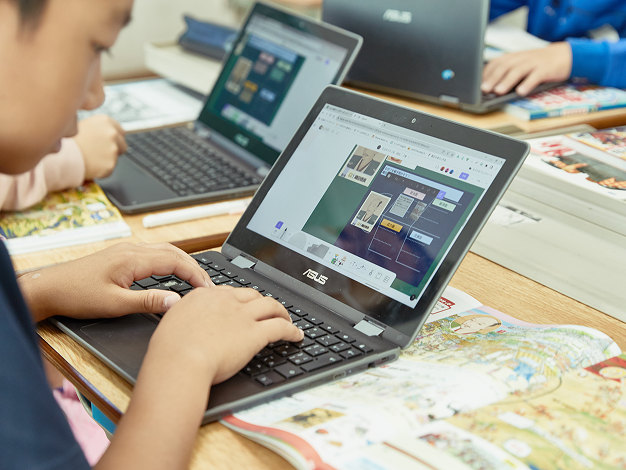 a young student typing on their laptop